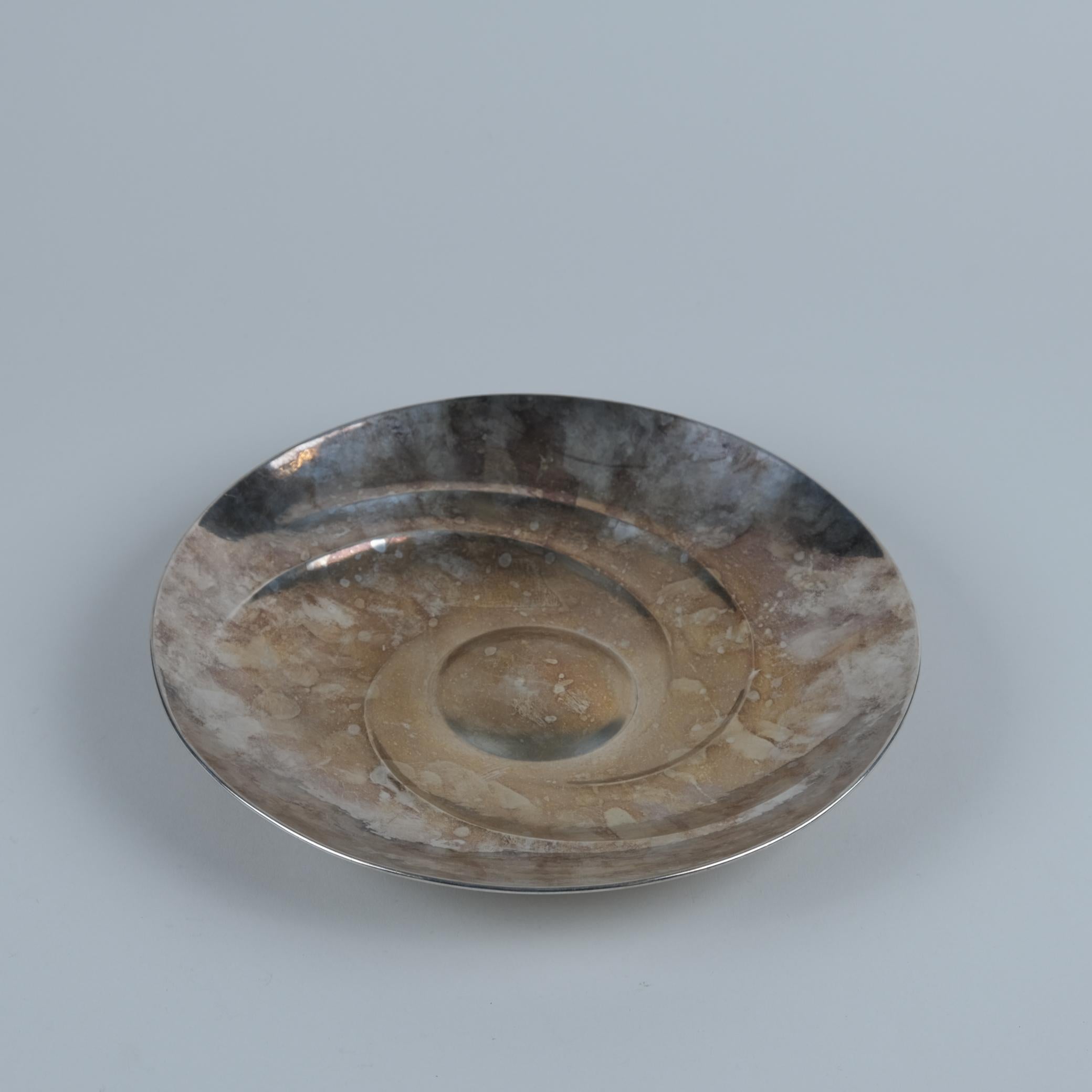 Un bellissimo piatto decorativo in argento, disegnato da Tapio Wirkkala e prodotto da Kultakeskus Oy nel 1973 in Finlandia. Questo pezzo è documentato nel libro di Tapio Wirkkala e il numero di modello è 143. Un centrotavola molto semplice ma