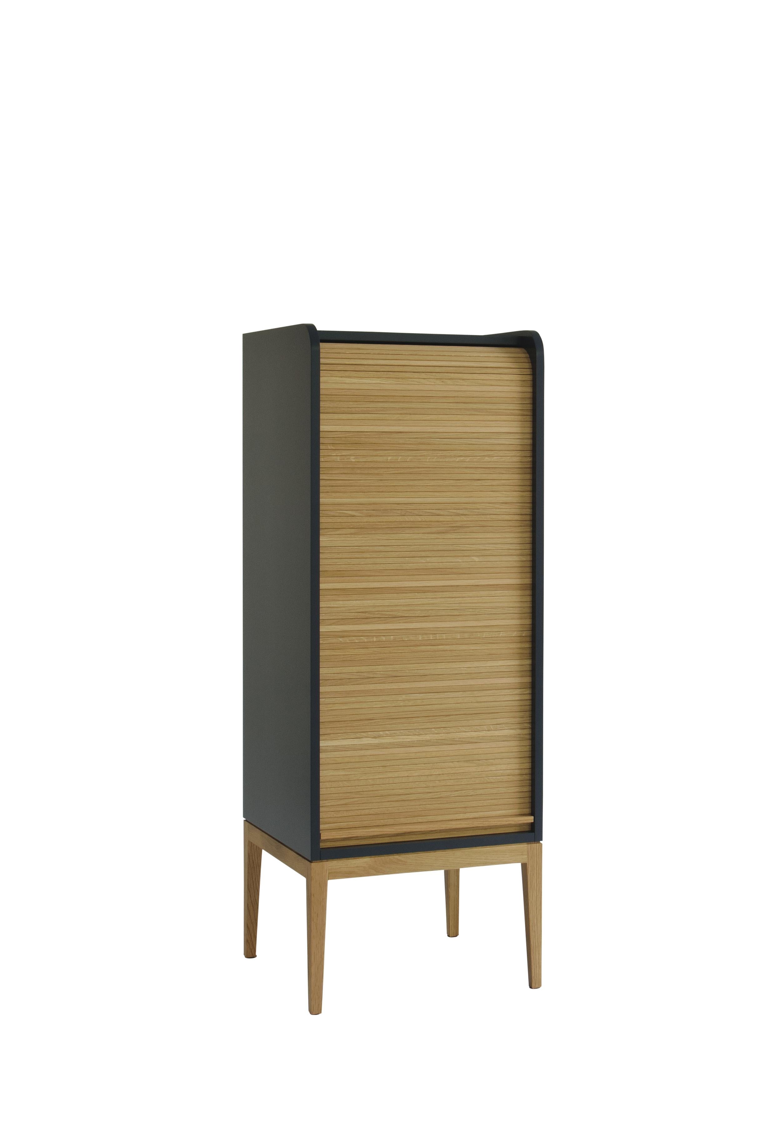 Tapparelle medium cabinet, blue / gray by Colé Italia with Emmanuel Gallina
Dimensions: H.115 D.42 W.42 cm.
Materials: Container with legs and “tapparella” sliding shutter in solid oak.
Matt lacquered structure; inside 2 oak veneered shelf

Also