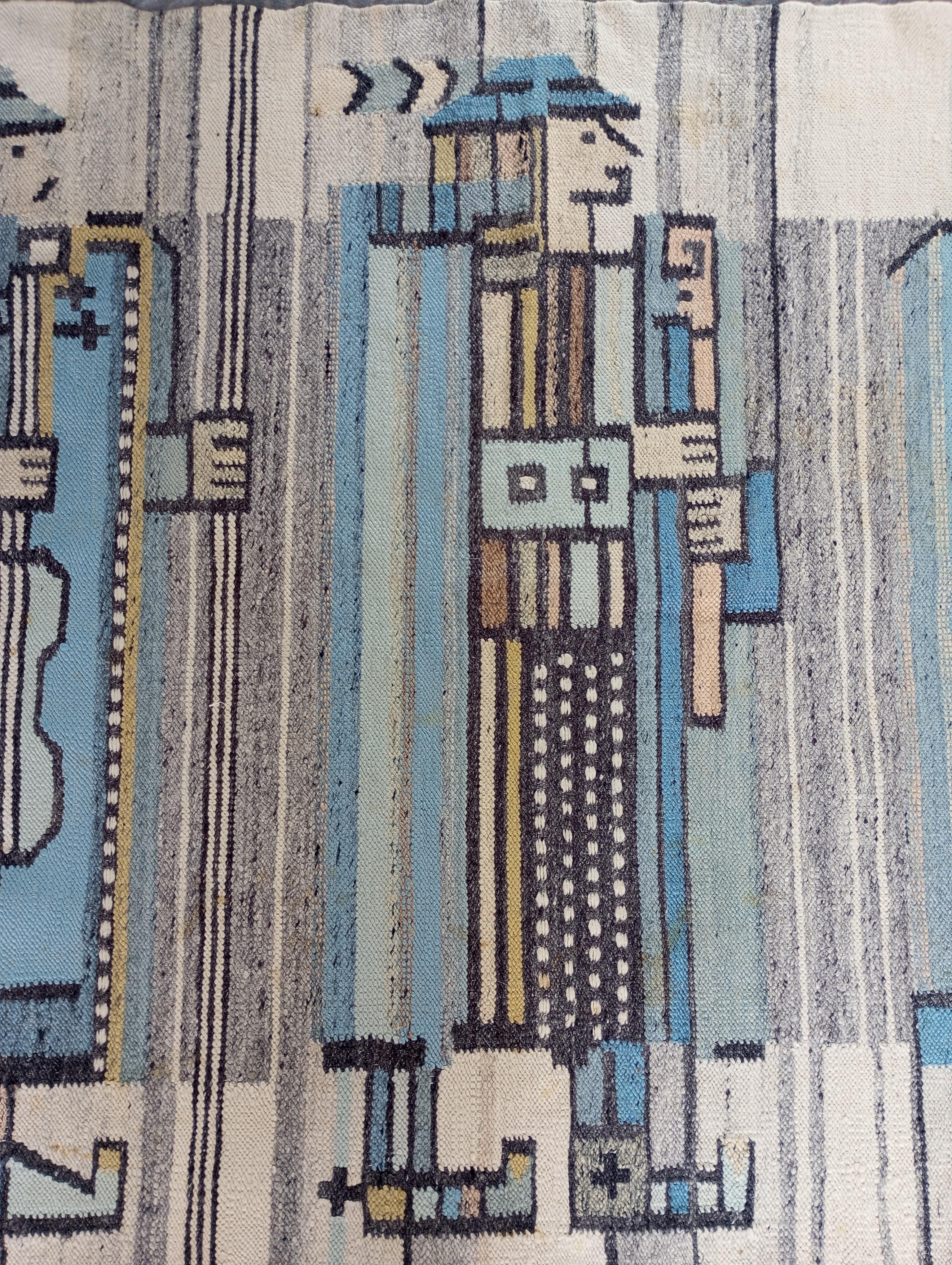 It is a handmade wool rug/arazzo, made with typical kilim technique and produced by Cepelia in Poland. Measuring 192 cm x 106 cm, this piece depicts three musicians playing traditional instruments, wearing typical clothes. The design skillfully