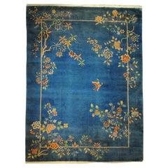 Blauer Hintergrund Art-Deco-Teppich mit einem Schmetterling und Kaskaden von mehrfarbigen Blumen