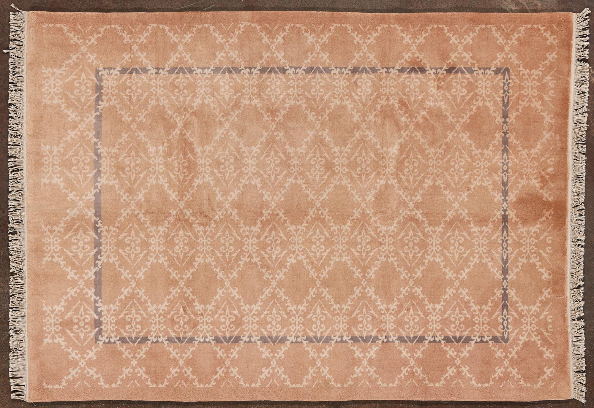 Tappeto di originale Cina Imperiale. Sulla superficie è presente un motivo geometrico ripetuto, con una cornice più scura che crea un effetto di profondità. I toni sono in colorazione pastello, prevalentemente rosa cipria con dettagli beige e una