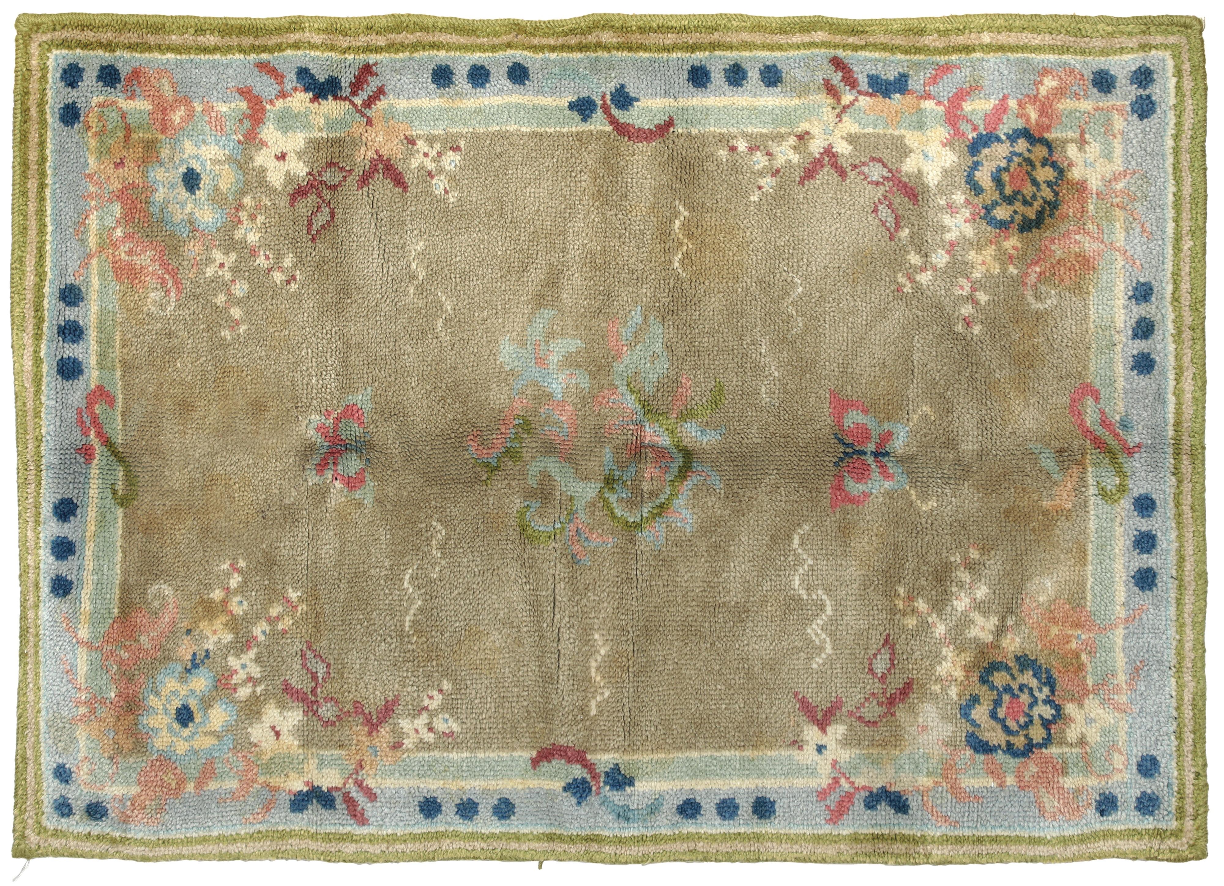 Realizzato a mano negli atelier di Cogolin, una cittadina nel sud della Francia rinomata per i suoi tappeti artigianali fin dal primo Novecento.
 Il tappeto presenta una decorazione centrale delicata con motivi floreali e farfalle, stilizzati in