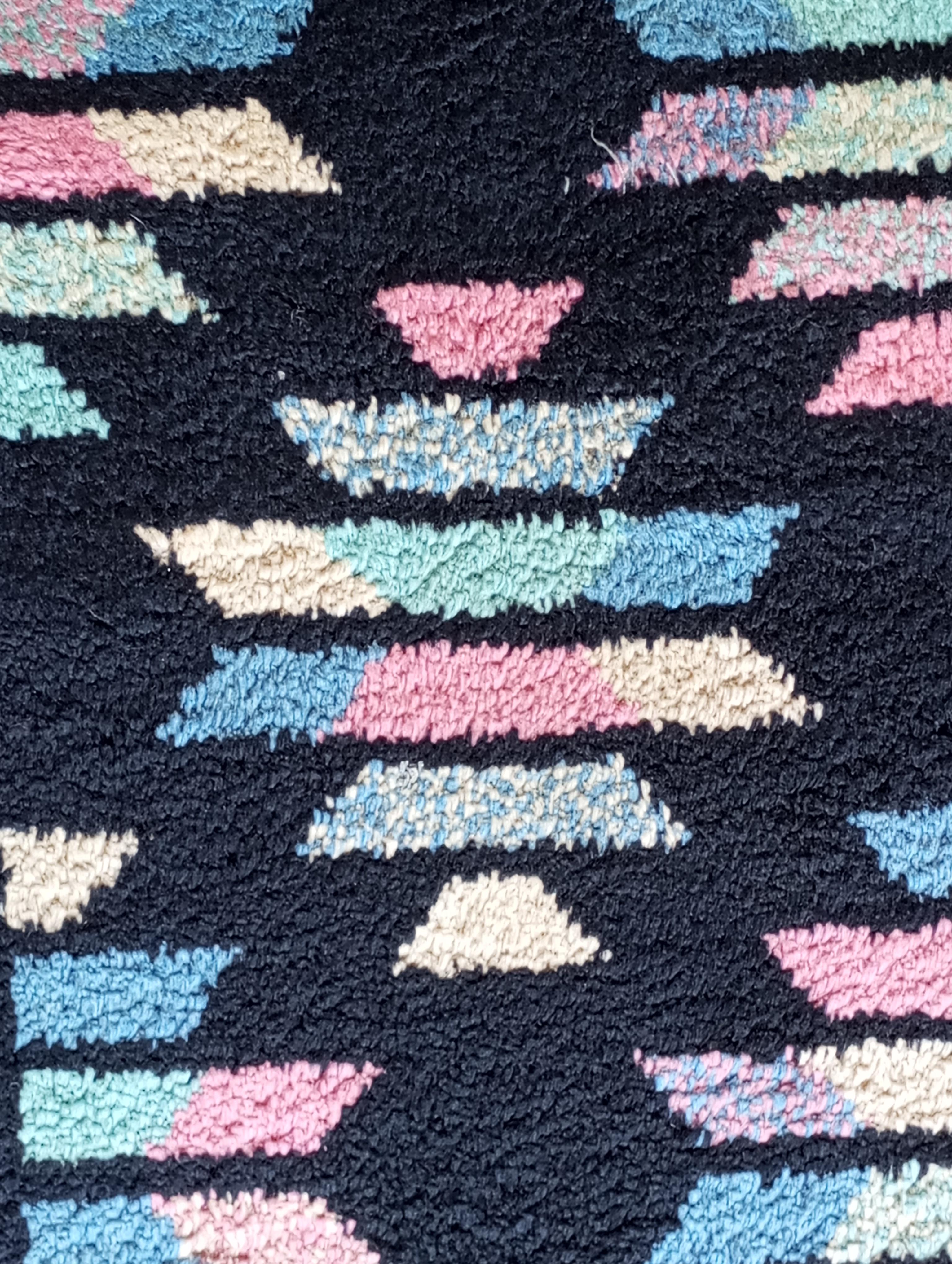 Tappeto a fondo nero in seta con disegni geometrici nei colori chiari di rosa, giallo, azzurro e verde che creano dei rombi con un contrasto elegante e sofisticato. Le sue dimensioni sono 223 cm. x 168 cm.
Il fondo nero, lucente e uniforme grazie