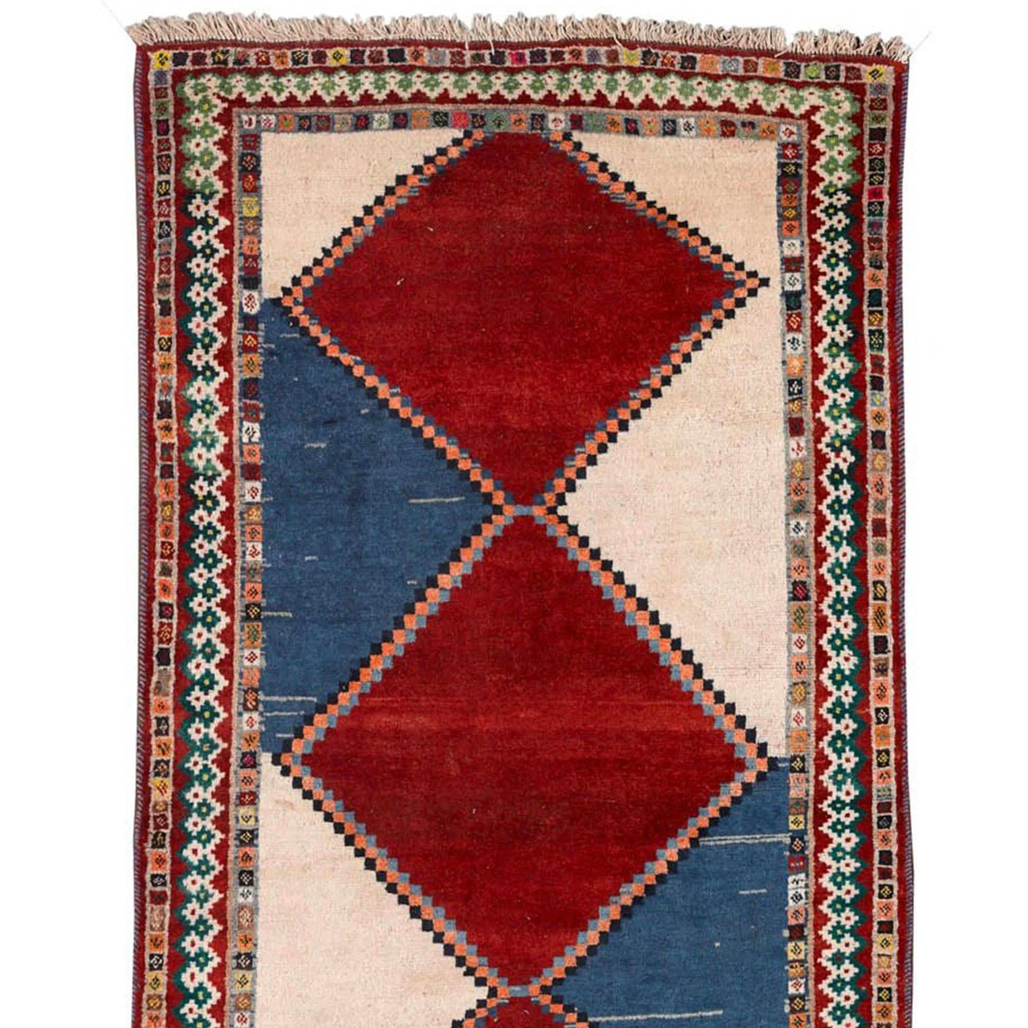 Handgeknüpfter Stammesteppich kaukasischen oder persischen Ursprungs, hergestellt im späten 19. und 20. Es zeigt ein geometrisches Muster mit drei großen roten Rauten in der Mitte, die sich mit blauen und beigen Abschnitten abwechseln. Die mit