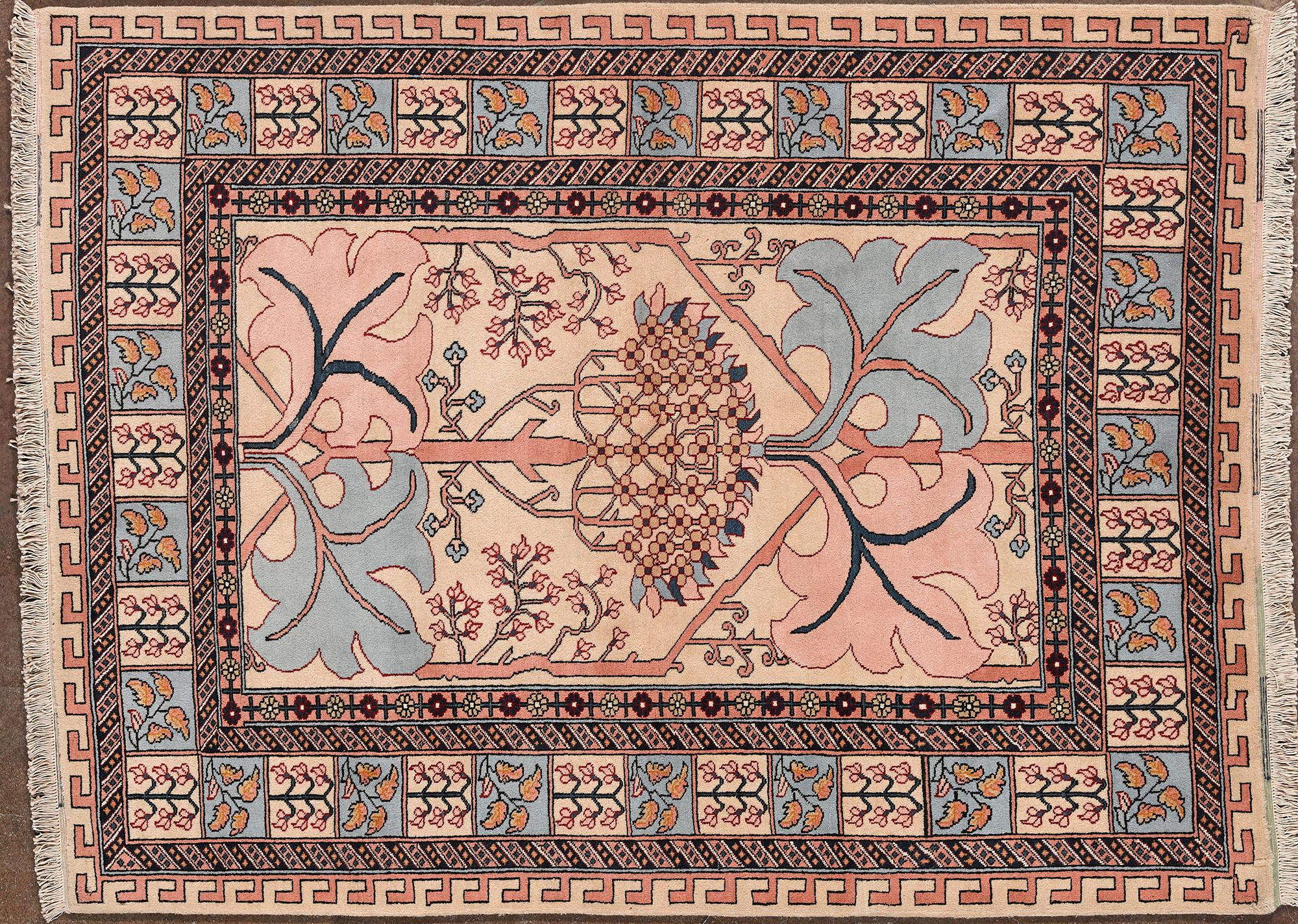 Alfombra Sarouk anudada a mano, Irán, siglo XX. Presenta un refinado motivo floral con el Árbol de la Vida, símbolo de crecimiento y continuidad, enmarcado por elegantes detalles vegetales en tonos azul, rosa y beige. El borde exterior está decorado