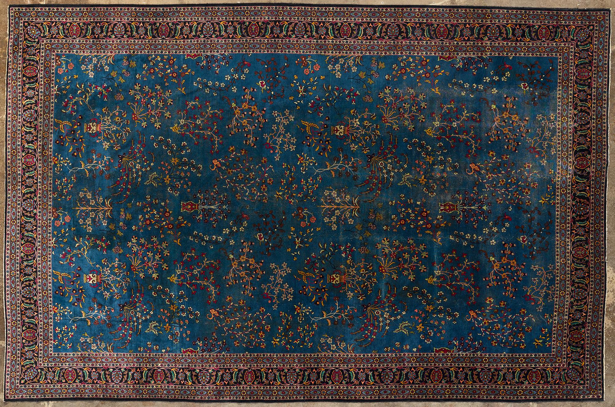 Tappeto di origine persiana classica, sulla cui superficie compaiono ornamenti floreali su sfondo scuro, bordatura elaborata con dettagli minuziosi. Il tono predominante è il blu scuro. Il tappeto è realizzato in lana annodata a mano.