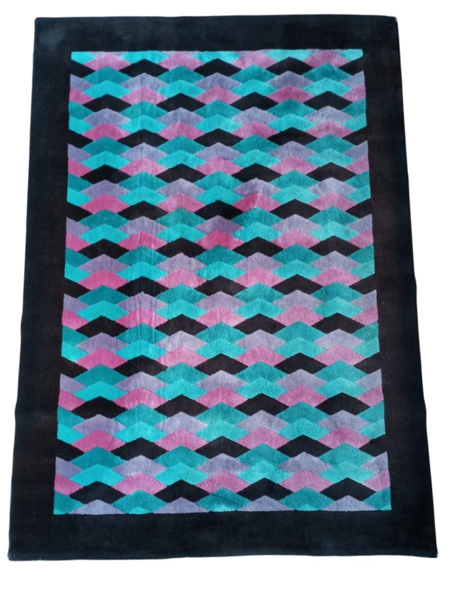 Tappeto Ottavio Missoni con design geometrico ispirato al motivo chevron, molto caratteristico del suo stile. Tappeto degli anni ’80 realizzato in lana dalla ditta T & J Vestor.
 Il disegno Chevron (zigzag), è realizzato con una disposizione