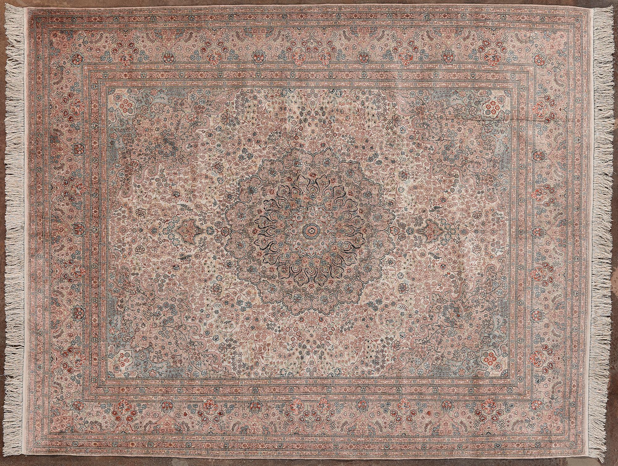 Alfombra de fabricación mongola. Elaborados motivos florales e intrincados arabescos se extienden por toda la superficie. La alfombra está dominada por delicados tonos beige, crema y gris, con toques rosas y azules. La alfombra es de lana anudada a