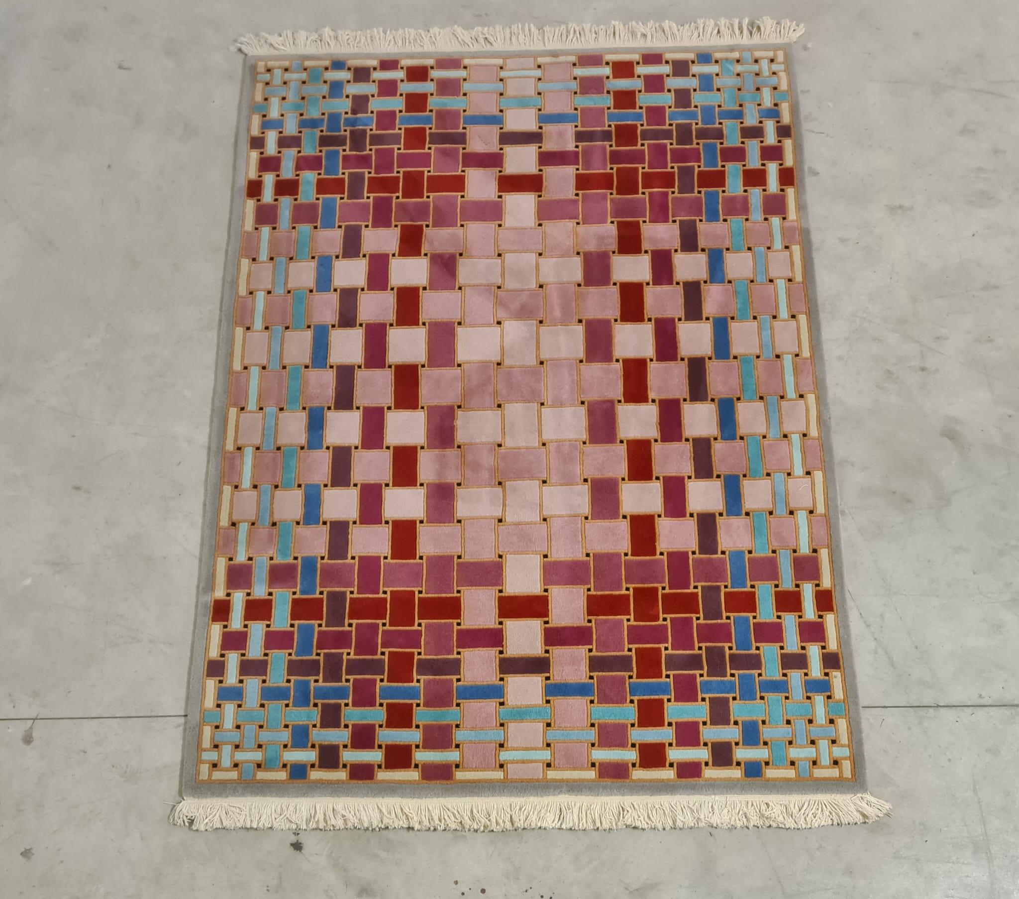 Optical rug in 1970s wool.

Refined mat with an optical pattern and bright colors.

Handmade of pure virgin wool with a gray background and shades of blue and pink that intertwine to create a unique geometric pattern.

Produced in a limited edition