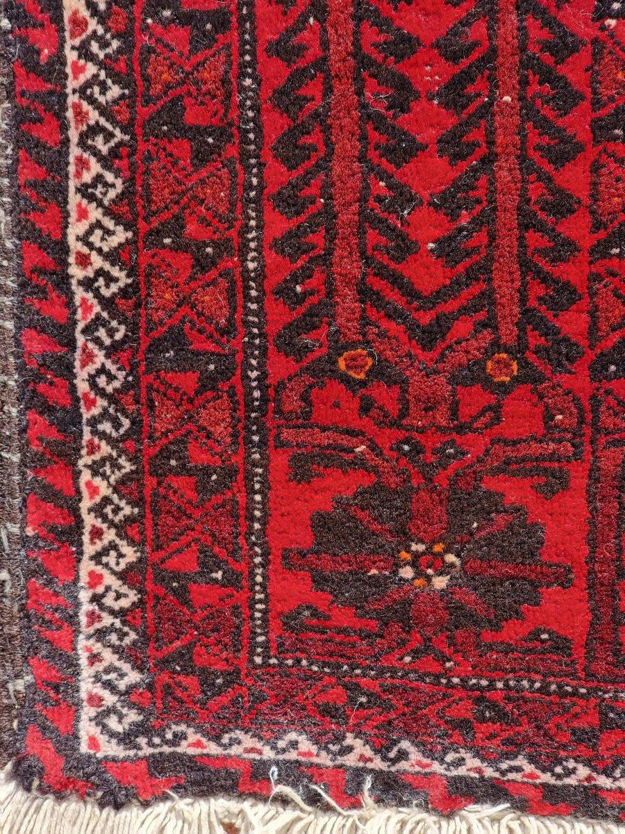 Tappeto persiano di probabile manifattura Baluch, annodato a mano nella prima metà del Novecento (anni '30-'50), proveniente dall’area orientale dell’Iran, al confine con l’Afghanistan. Di formato contenuto (180 x 96 cm), presenta una decorazione