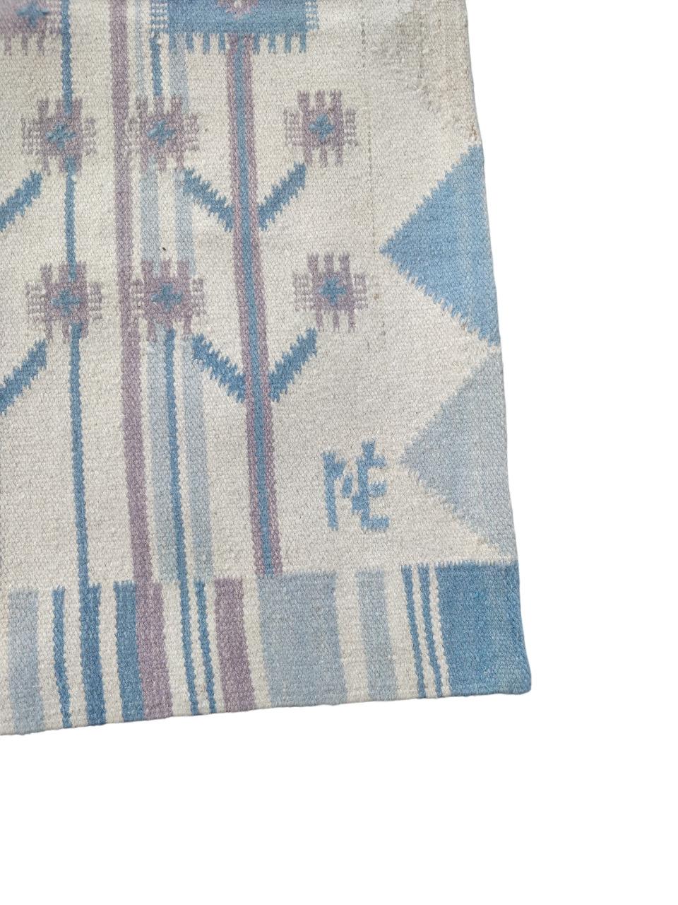 Tappeto-arazzo tessuto a mano in lana, il suo design, c nelle tonalità dell’azzurro, rappresenta uccelli e fiori stilizzati. In basso a destra sono presenti le iniziali del designer, NE Nemeth Eva. Anni '70.
Éva Németh (1930-2019) è stata una