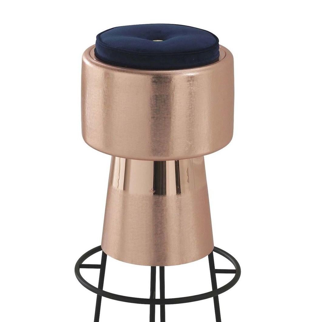 Made of copper with a brushed finish, this stunning stool is a sculptural work of art reminiscent of a champagne cork. Supported by a metal structure, it features a soft and comfortable navy blue velvet seat. This original and plush design can also