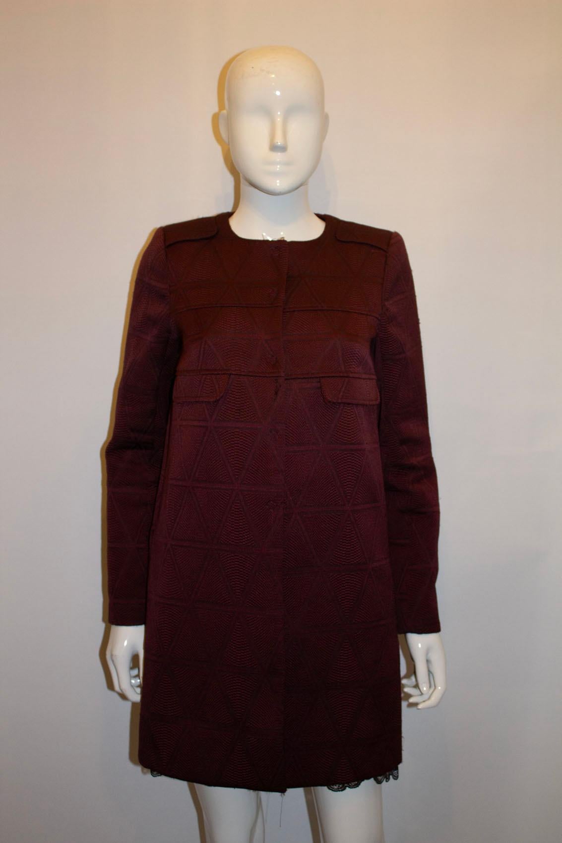A chic coat by Tara Jarmon  . In a wonderful textured fabric and attractive aubergine colour , the coat has a popper front fastening.
Size 38 Measurements Bust up to 38'',length 33''