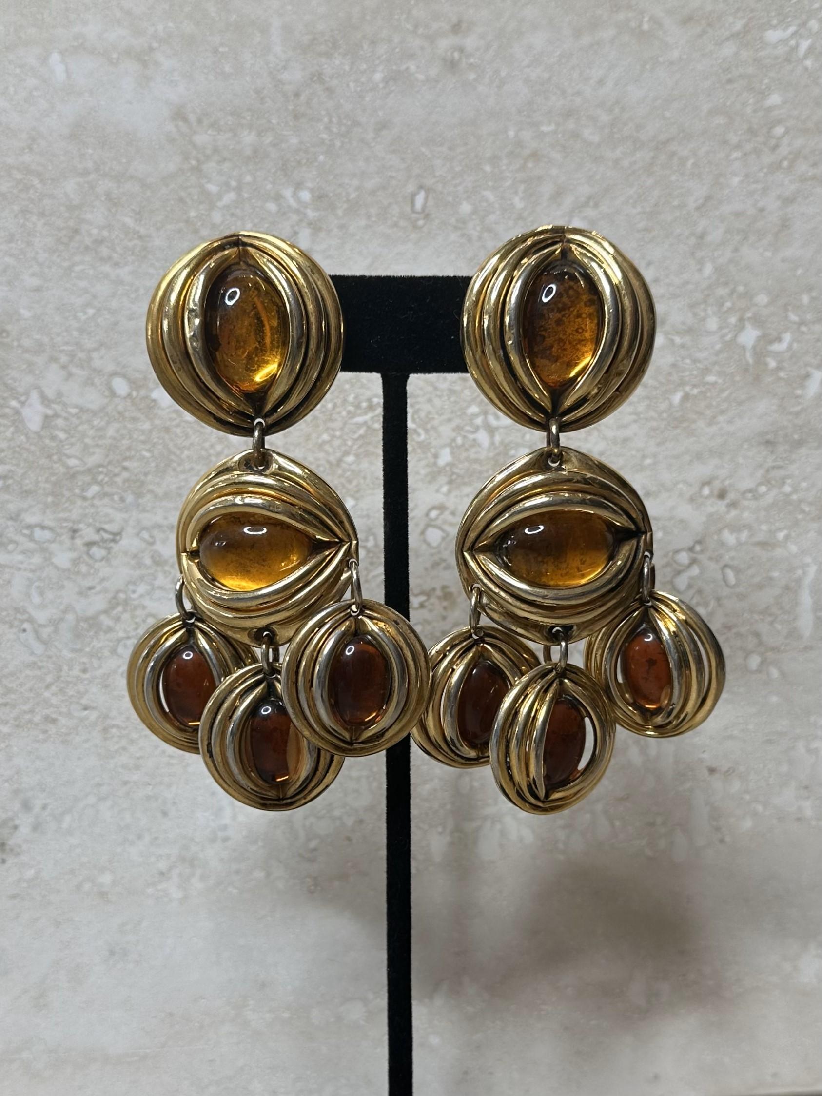 The Taratata France Gold Amber Drop Clip-On Earrings are a striking and elegant piece of jewelry from the French brand Taratata, known for its bold, vintage-inspired designs and intricate craftsmanship. These earrings would likely feature amber, a