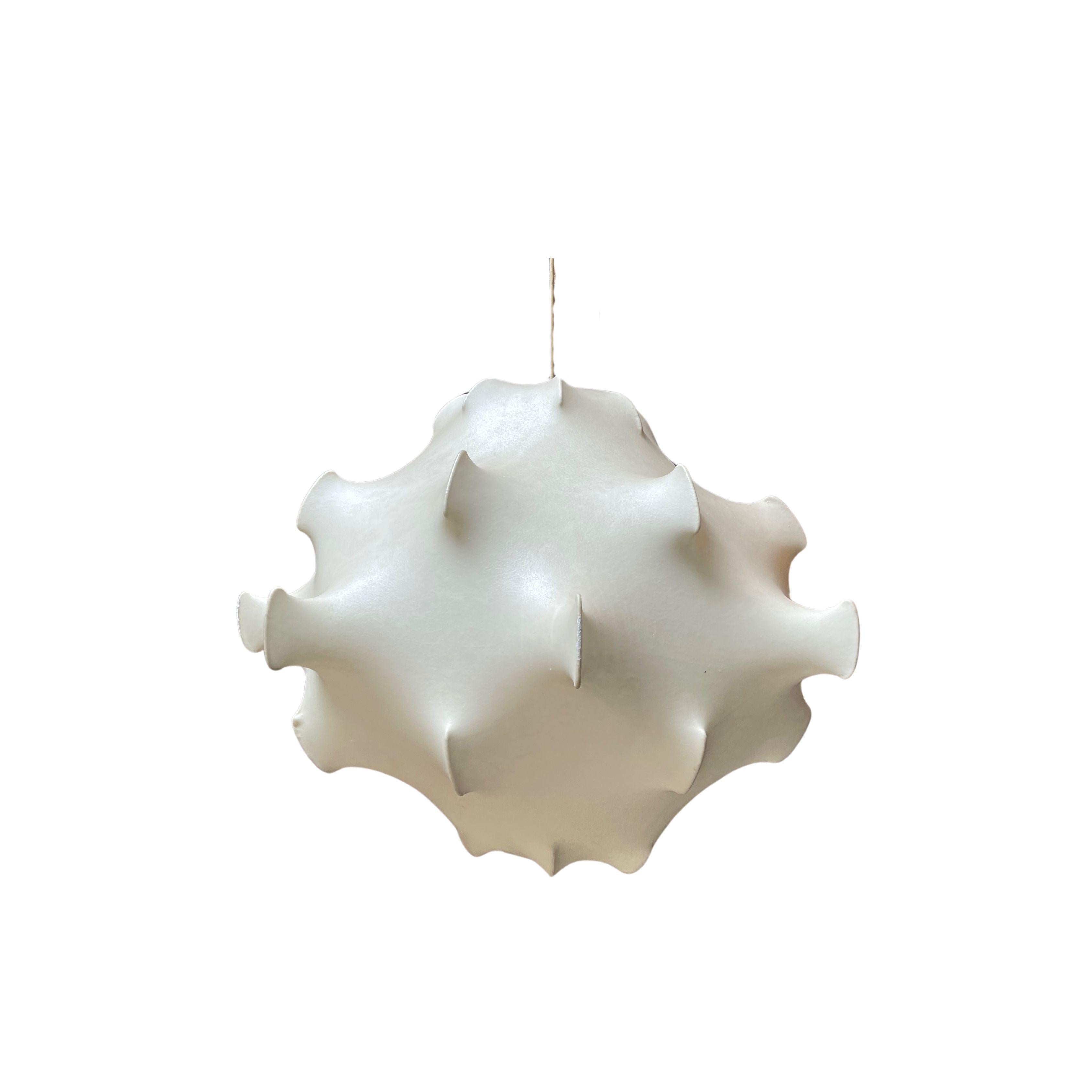 Iconica lampada a sospensione disegnata dai fratelli Castiglioni per Flos a metà del XX secolo. Questa lampada si ispira ai denti di leone ed è realizzata spruzzando la resina cocoon su una struttura in acciaio bianco verniciato a polvere. Include