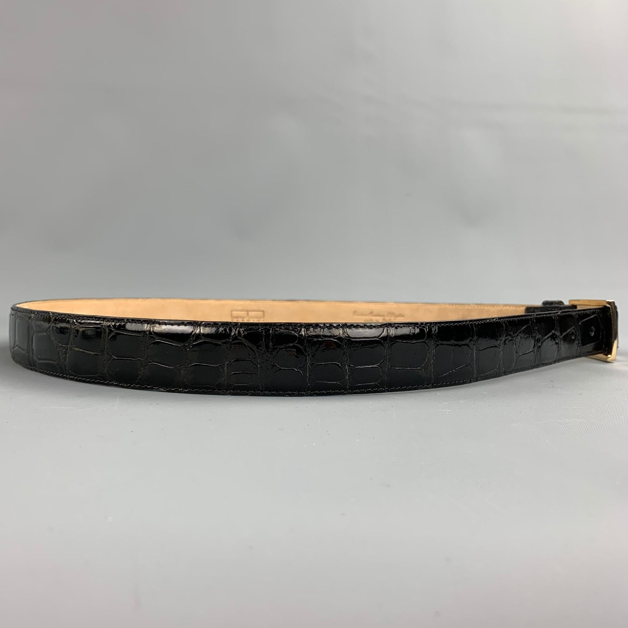 TARDINI belt comes in a black textured alligator leather featuring a gold tone buckle closure. Made in Italy.

Very Good Pre-Owned Condition.
Marked: 40/100
Original Retail Price: $850.00

Length: 47 in. 
Width: 1 in. 
Fits: 37 in. - 41 in. 
Buckle: