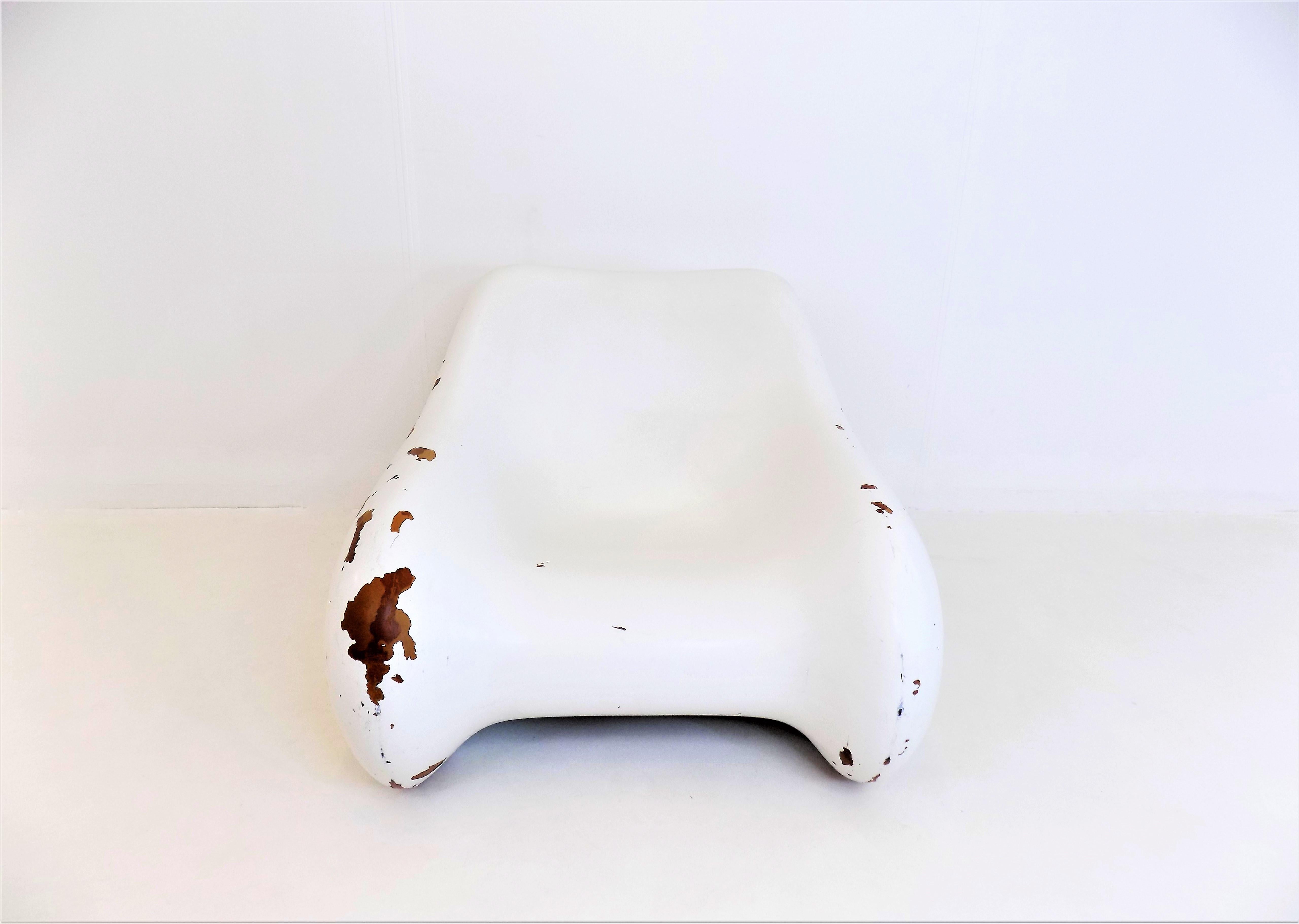 This armchair, made of solid fiberglass, appears light as a feather due to its airy lines. Over the years it has acquired a patina which increases the charm of this piece. Paint chipping present in several places on the armchair. The structure is