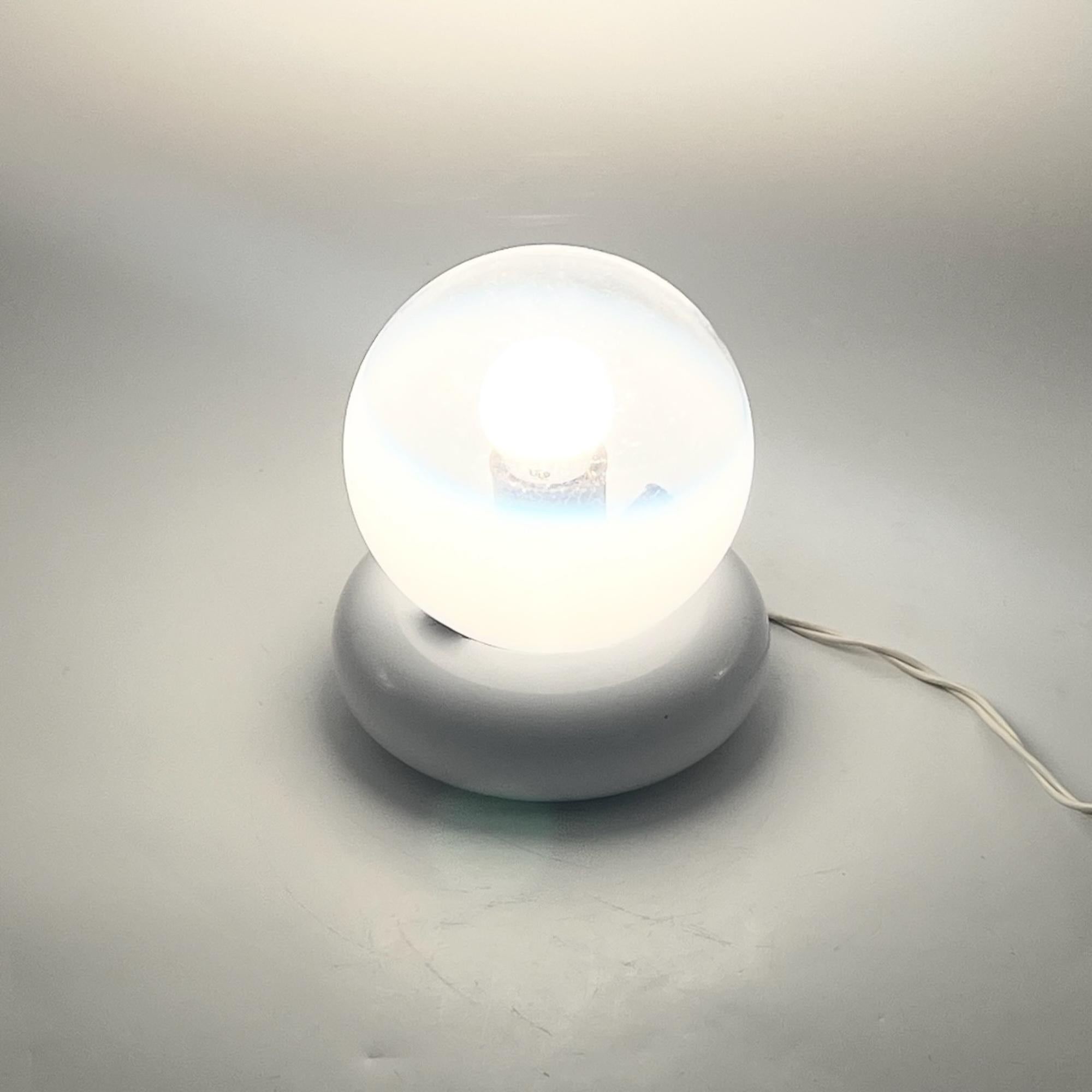 Elevate your decor with this stunning vintage Targetti Sankey table lamp, a perfect blend of modernist white metal bases and an artistically crafted glass sphere. The glass globe, transparent with subtle white gradients, creates a mesmerizing visual