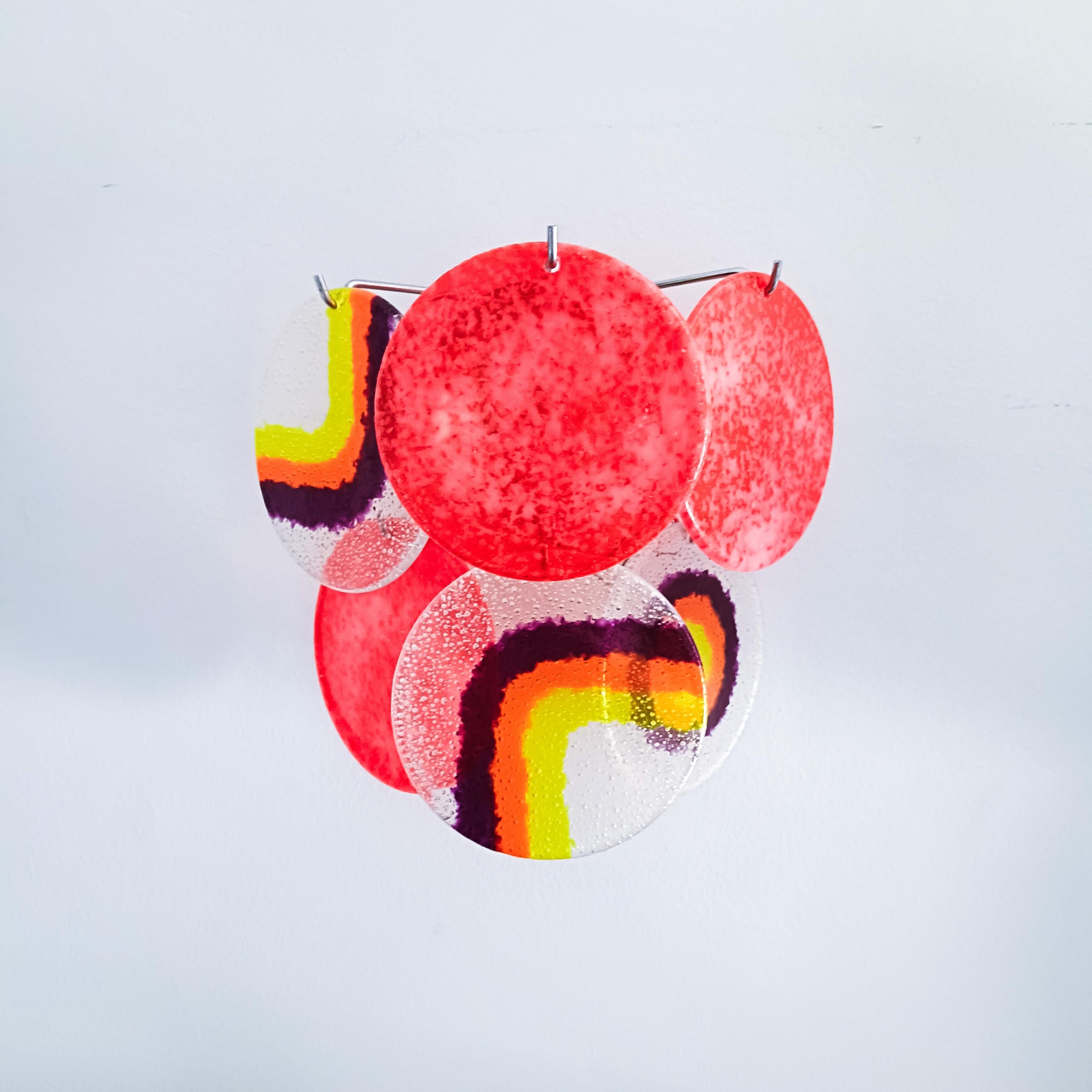 Conjunto de 4 apliques italianos de Targetti Sankey, década de 1970. Cada pieza tiene una estructura metálica cromada en plata donde se sujetan 6 discos de acrílico o metacrilato con diferentes motivos, combinando colores amarillo, naranja, morado,