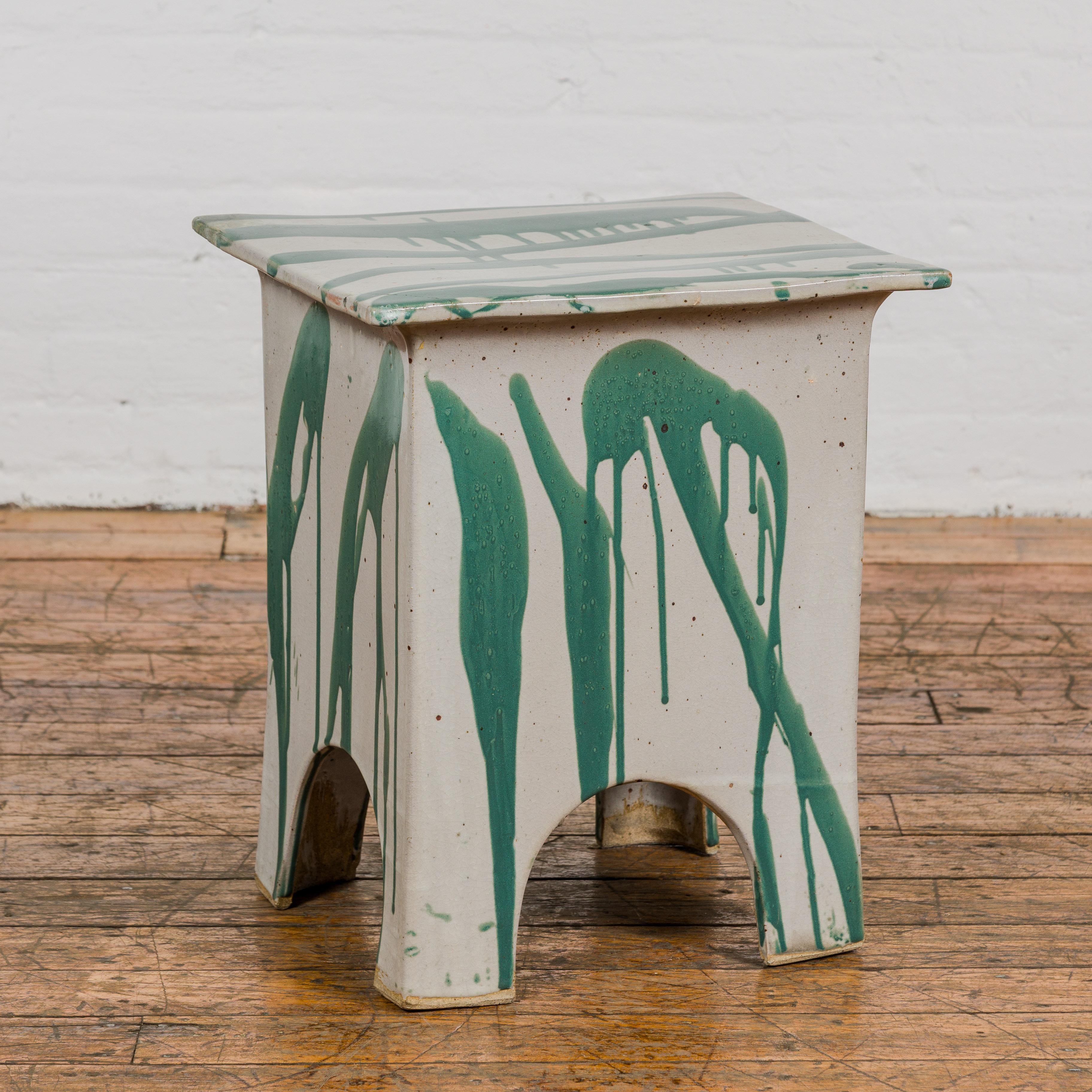 A Tariki Studio ceramic garden seat with green and light gray glaze. Embrace the tranquility of your outdoor haven with this exquisite ceramic garden seat from Tariki Studio, a fusion of modern design and artisanal craftsmanship. Its harmonious