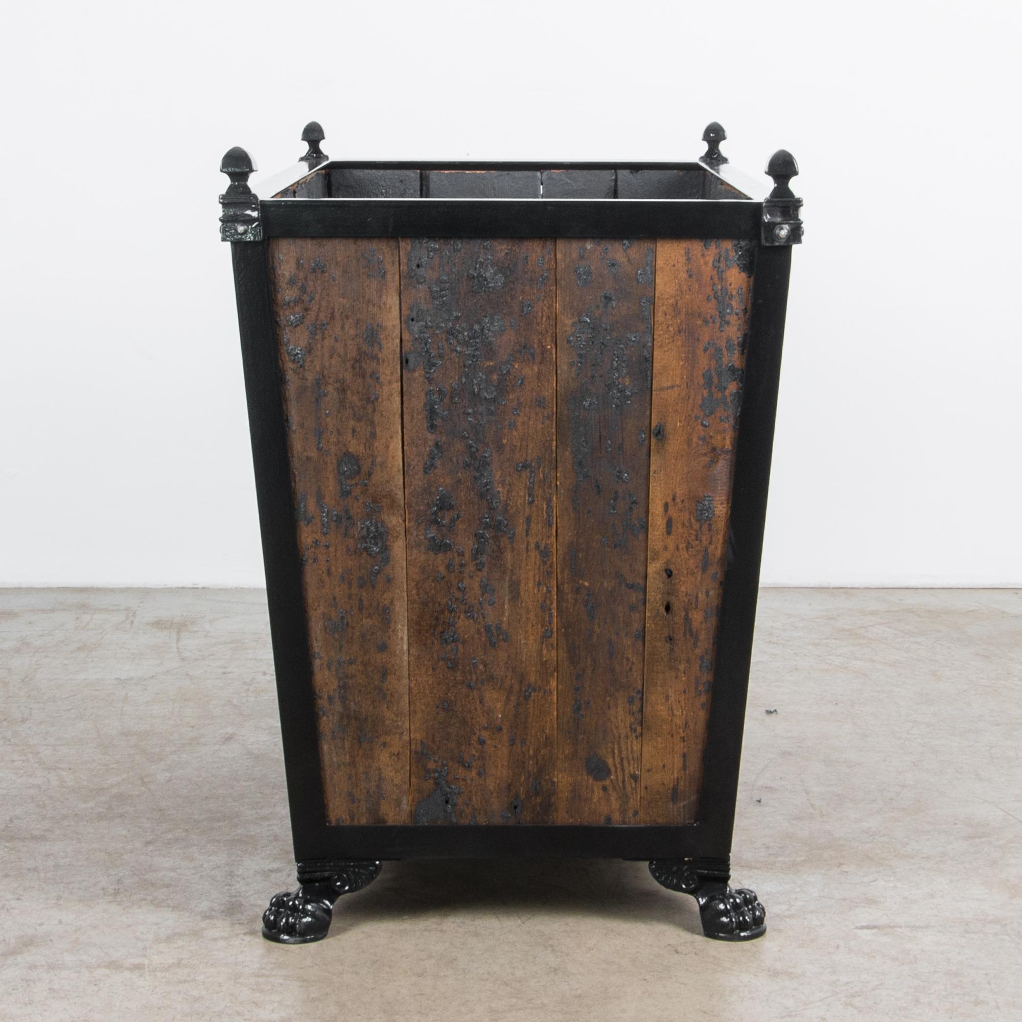 A sturdy wooden garden planter produced in our atelier. Finished with dramatic black tar, this wooden planter combines aged pine and sleek painted metal for an atmospheric dark textured look. The textured finish compliments a classic combination of