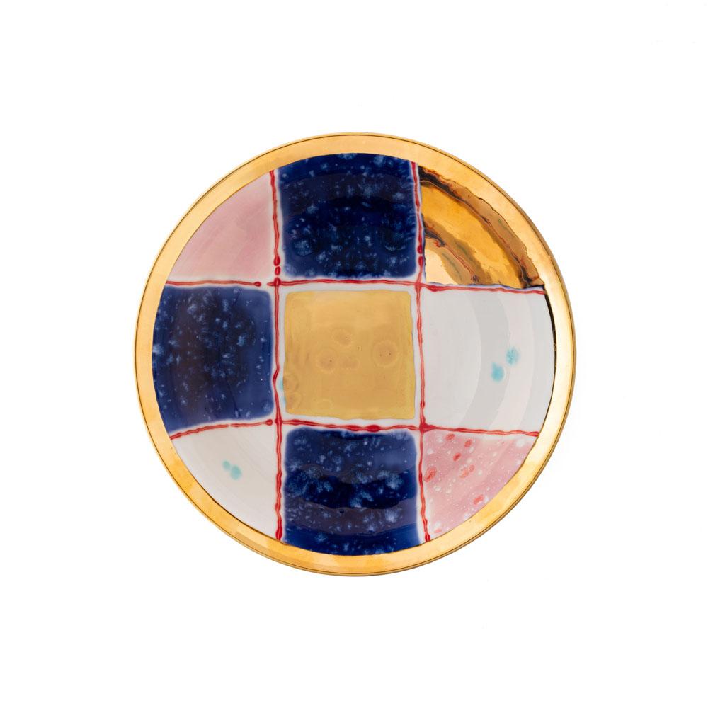 The Gold Impressions collection takes Coralla's exploration of geometry and minimalism to a new dimension, infusing her iconic designs with radiant gold accents. These golden elements transform familiar symbols, like the Mountain, into luminous