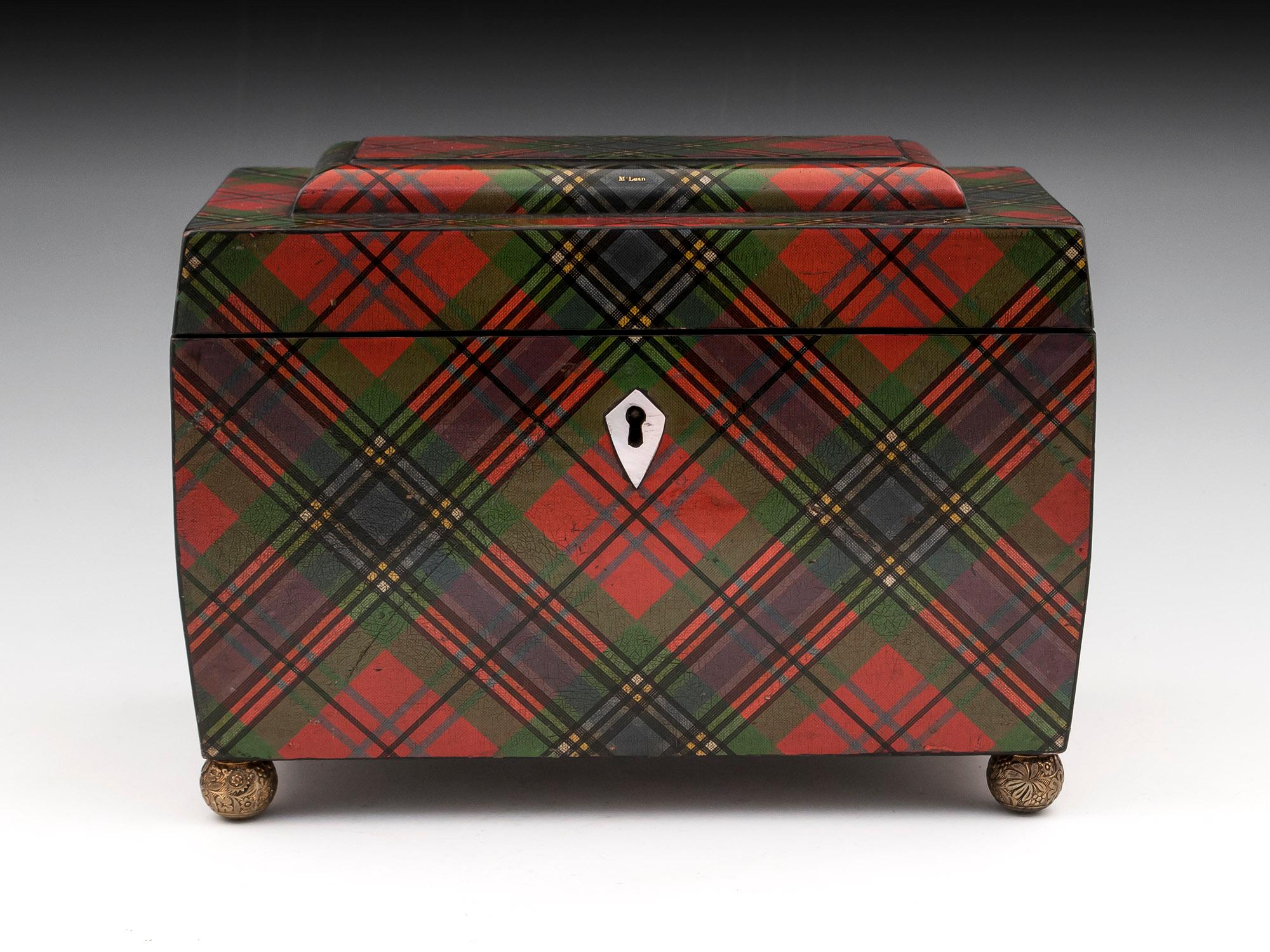 Tartan Ware tea caddy with shaped mother of pearl escutcheon. Opening this fabulous Tartan Ware Tea Caddy reveals two hinged sycamore lids, one foil debossed with the 
“Smiths Mauchline Ware” 
Royal Warrant. Stands on floral pressed ball feet.