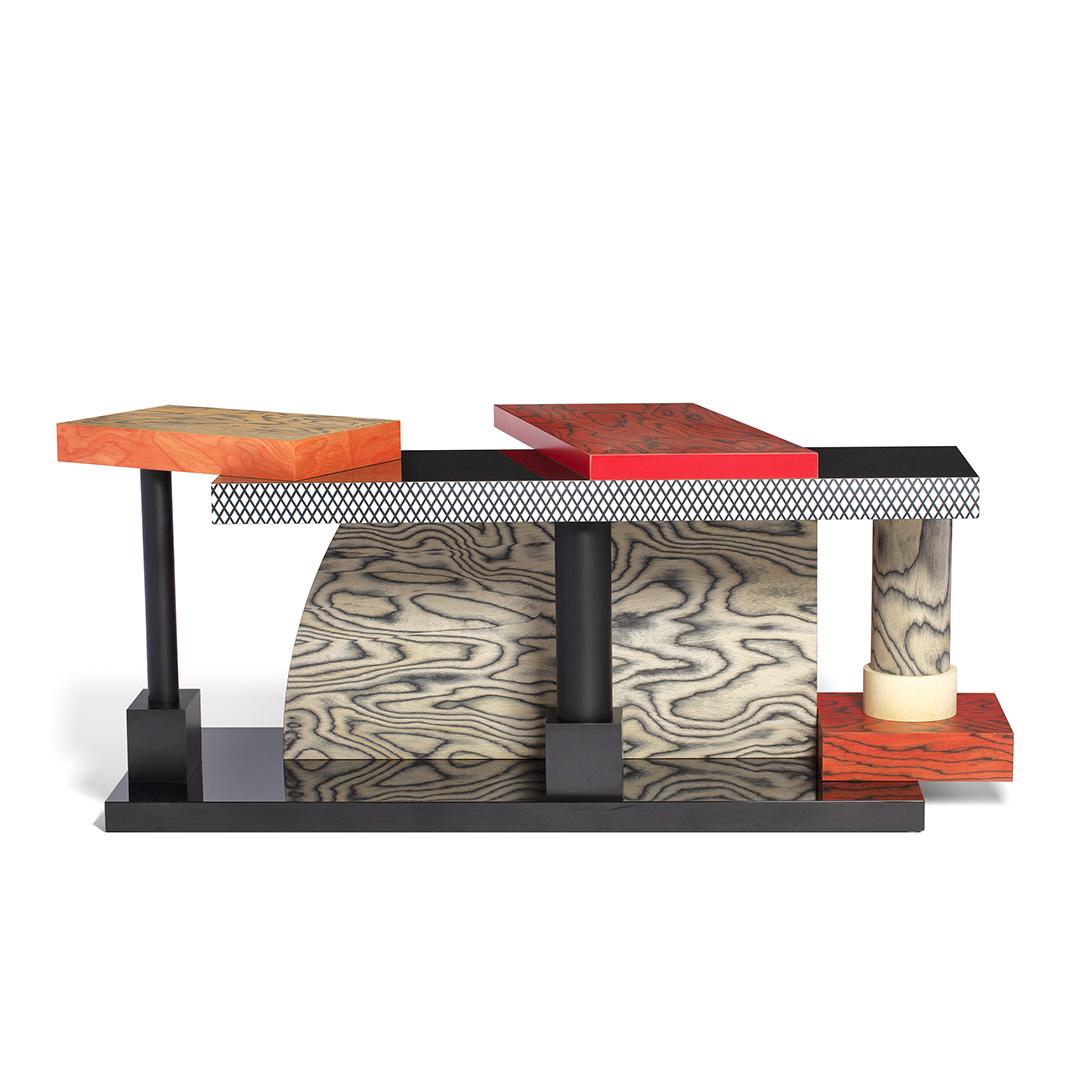 Der Tartar Tisch aus laminiertem Holz wurde 1985 von Ettore Sottsass für Memphis Milano entworfen.

Ettore Sottsass wurde 1917 in Innsbruck geboren. Im Jahr 1939 schloss er sein Architekturstudium am Politecnico di Torino ab. Eine der