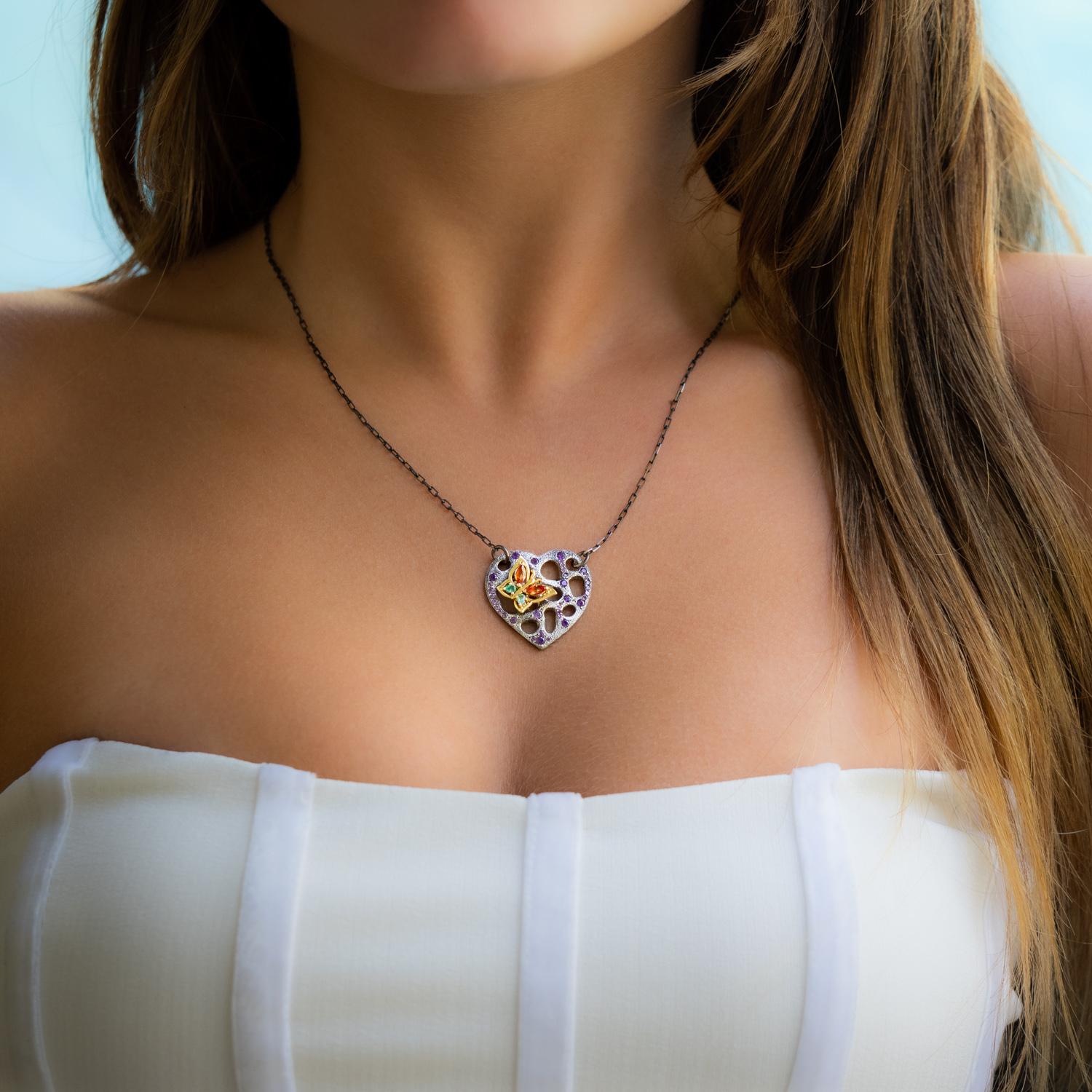 This enchanting heart and butterfly necklace is crafted from 18K rose gold and sterling silver, adorned with emeralds, sapphires and amethyst. The butterfly, perching upon the heart with an amethyst face, bring color and awaken a sense of lightness