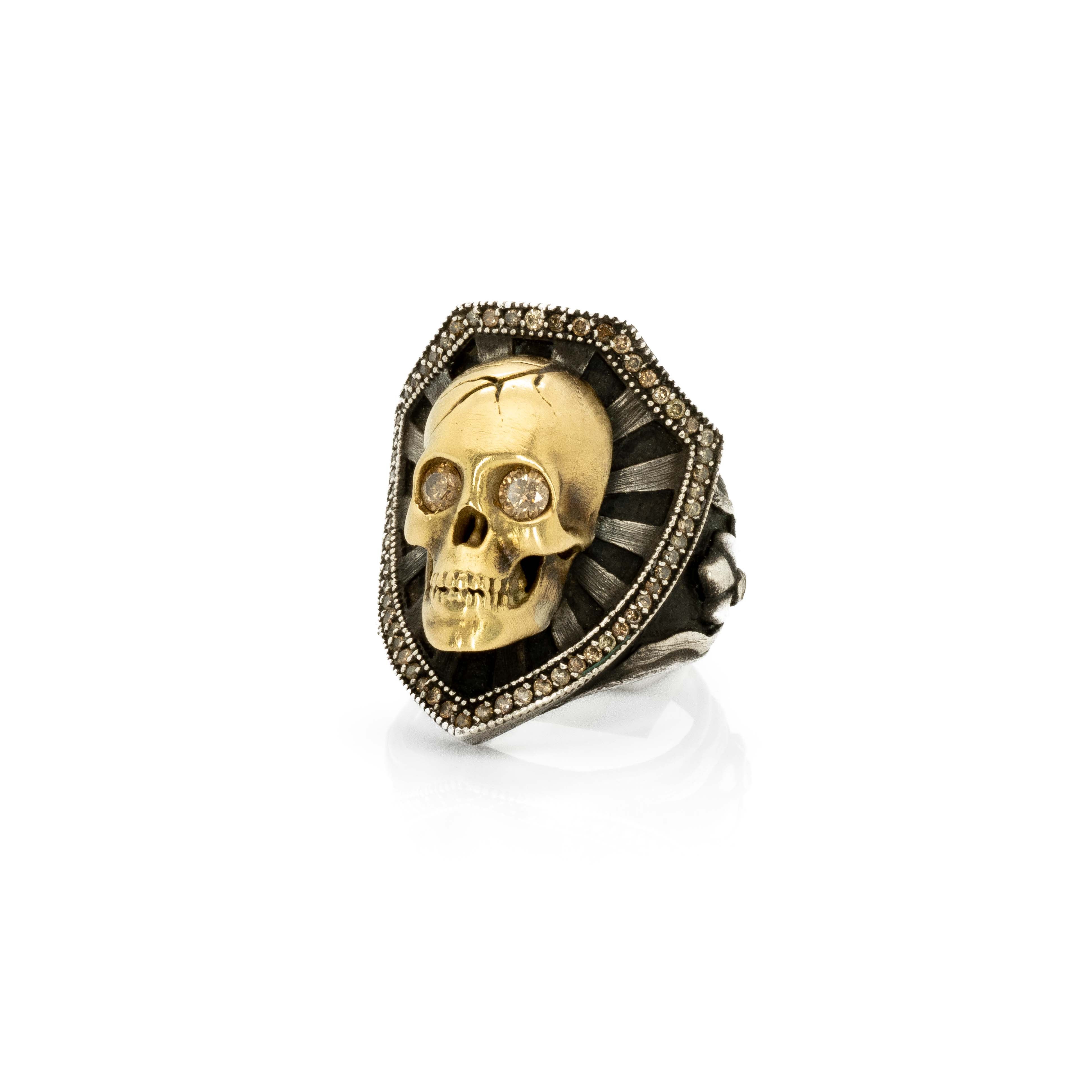 The Skull & Shield ring features a gorgeous 18k gold skull and a medieval shield made of oxidized sterling silver, framed with brown diamonds. The eyes of the skull, also set with brown diamonds, adds a special glare to the ring.

Skull & Shield