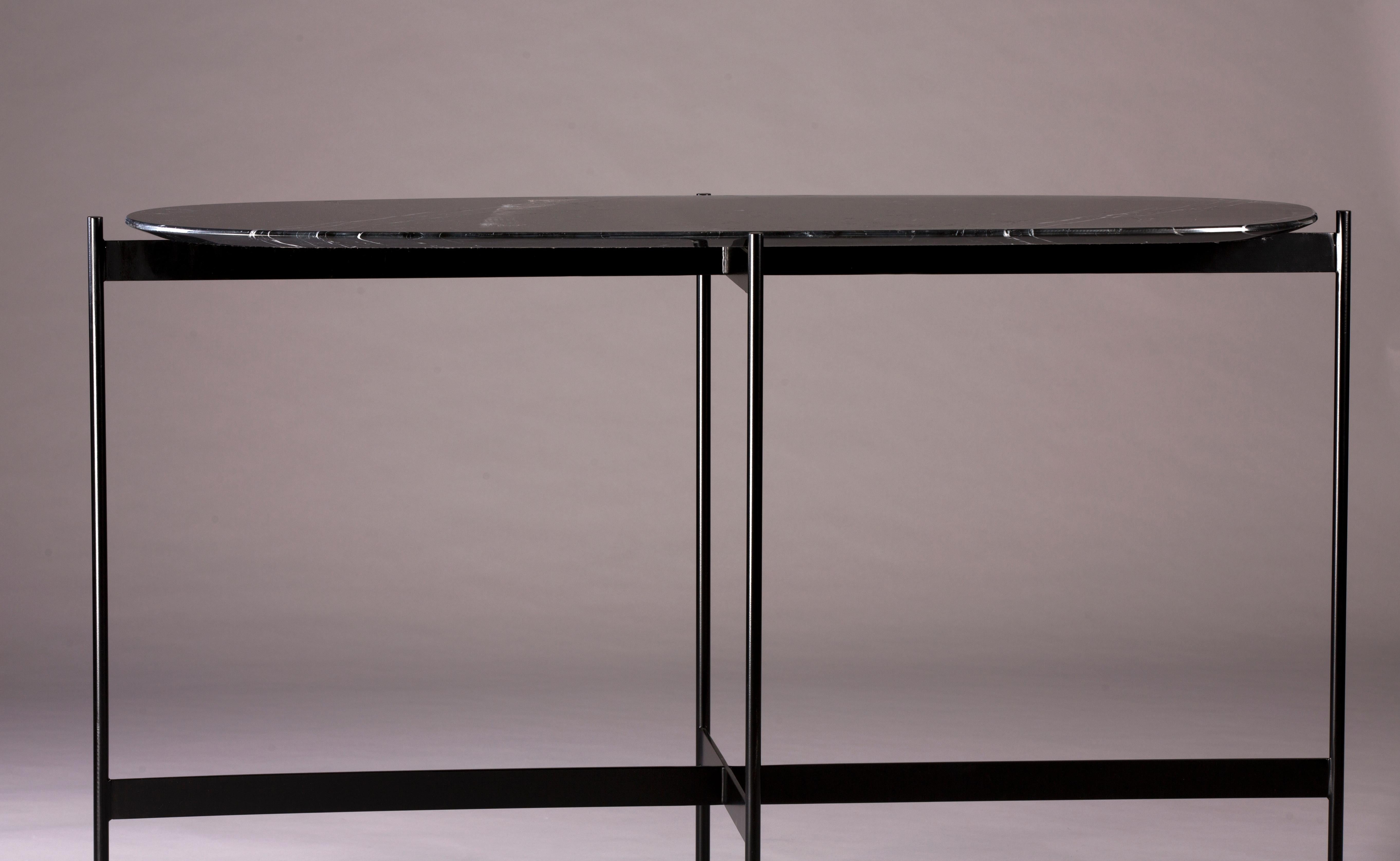 Tas console by Rectangle Studio
Dimensions: W 125 x D 45 x H 75 cm 
Materials: Black marble, black paint coating on metal

The table is shaped and finished by the designer. For this reason, each table has different and distinctive edge finishes.