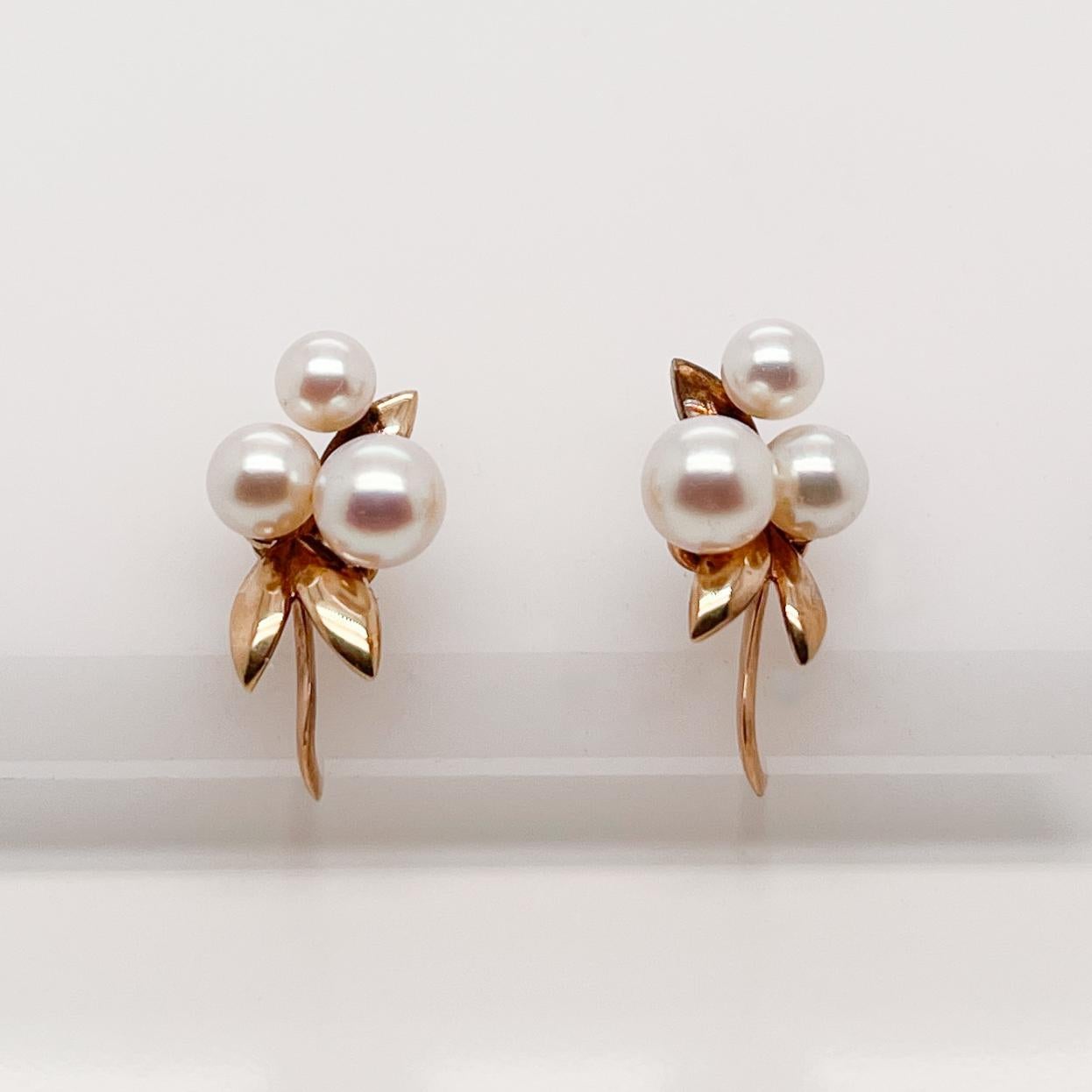 A very fine pair of 14K gold Tasaki Akoya pearl screw-back earrings.

With graduated round white pearls in a cluster set on 14k gold post with gold leaves. 

Simply a wonderful pair of earrings!

Date:
20th Century

Overall Condition:
It is in