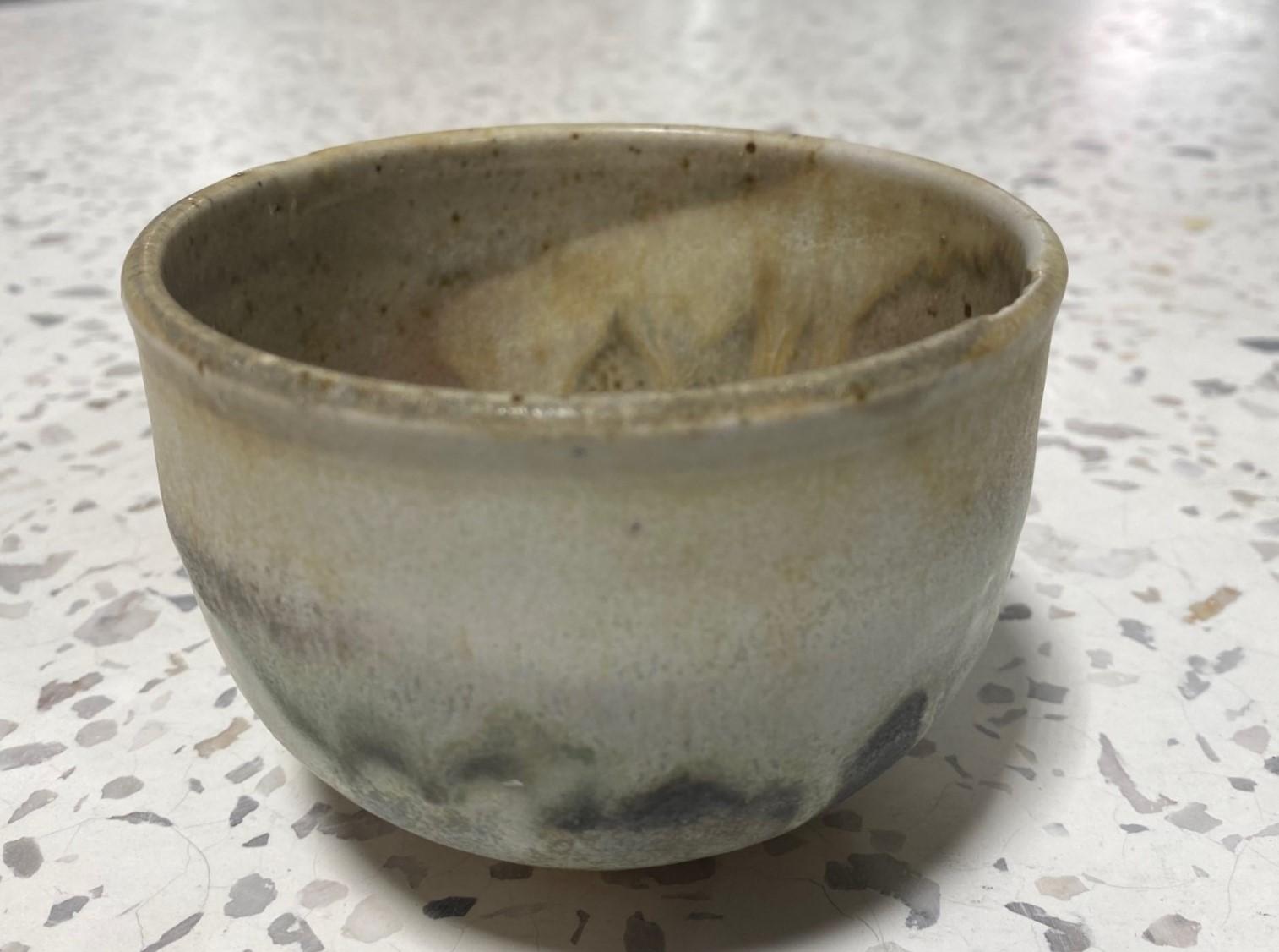 A beautiful and quite engaging Chawan tea bowl by famed Japanese Hawaiian American pottery master Toshiko Takaezu. The fired bowl features a vast array of shifting, vibrant, and colorful glazes (with earth tones of browns, greens,  black, greys, and