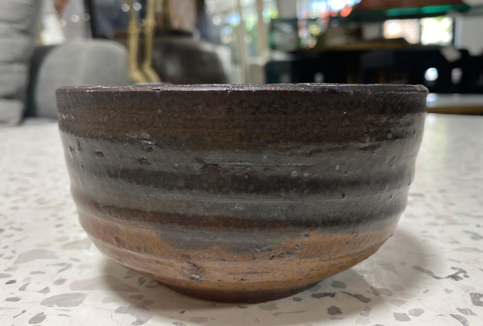 Una bellissima e affascinante ciotola da tè Chawan sontuosamente smaltata dal famoso maestro di ceramica giapponese hawaiano-americano Toshiko Takaezu. La ciotola cotta presenta una vasta gamma di smalti mutevoli, vibranti e colorati (con toni della