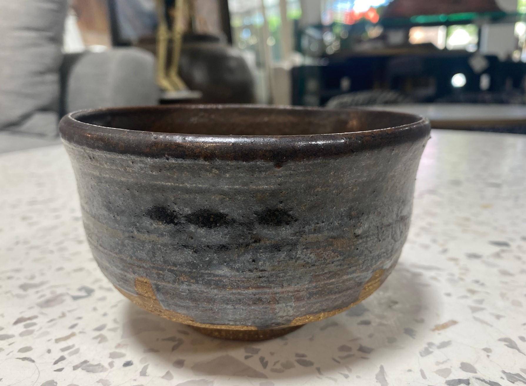 Magnifique et très attachant bol à thé Chawan relativement grand, somptueusement émaillé, du célèbre maître de la poterie japonaise hawaïenne américaine Toshiko Takaezu. Le bol cuit présente une glaçure Tenmoku goutte à goutte avec une gamme de tons