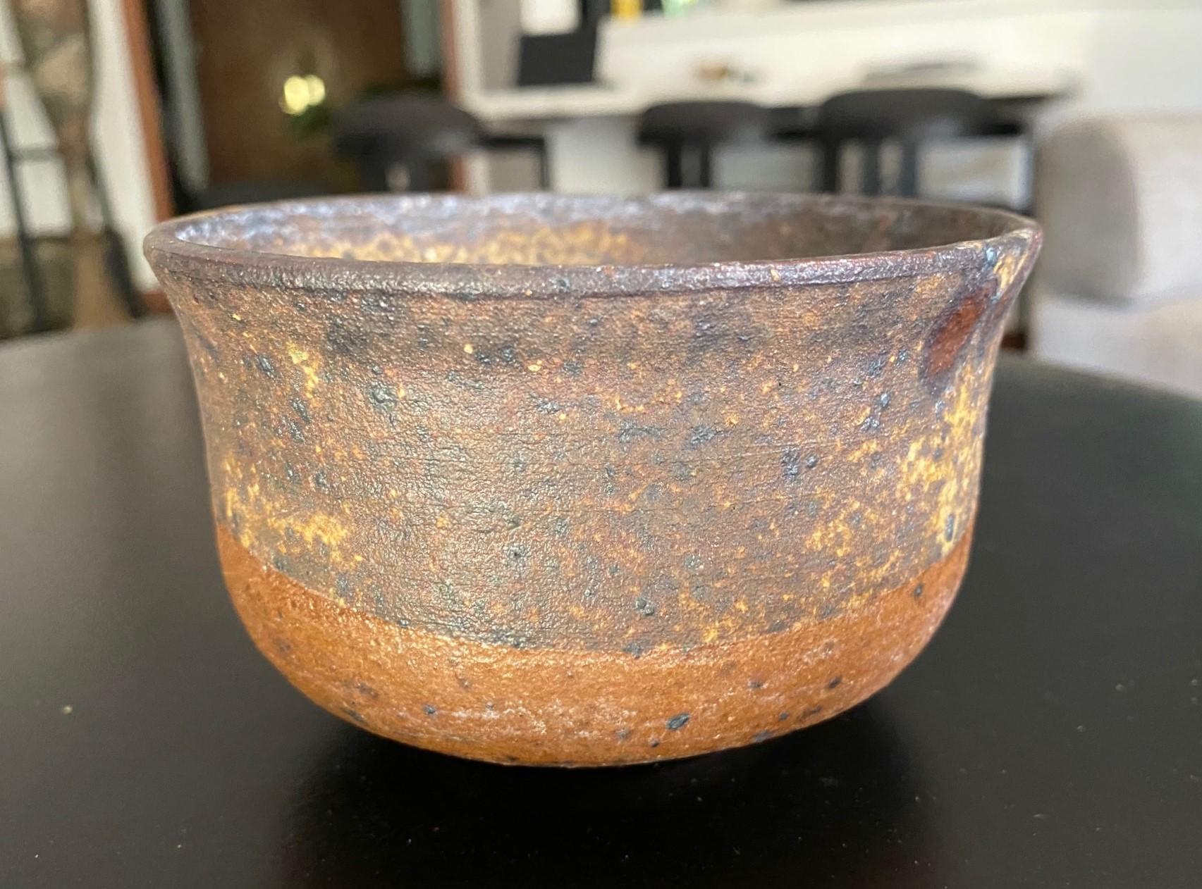 Un magnifique et très attachant bol à thé Famed du célèbre maître de la poterie japonaise hawaïenne américaine Toshiko Takaezu. Le bol en grès cuit présente une vaste gamme de glaçures changeantes, vibrantes et colorées (avec des tons de terre