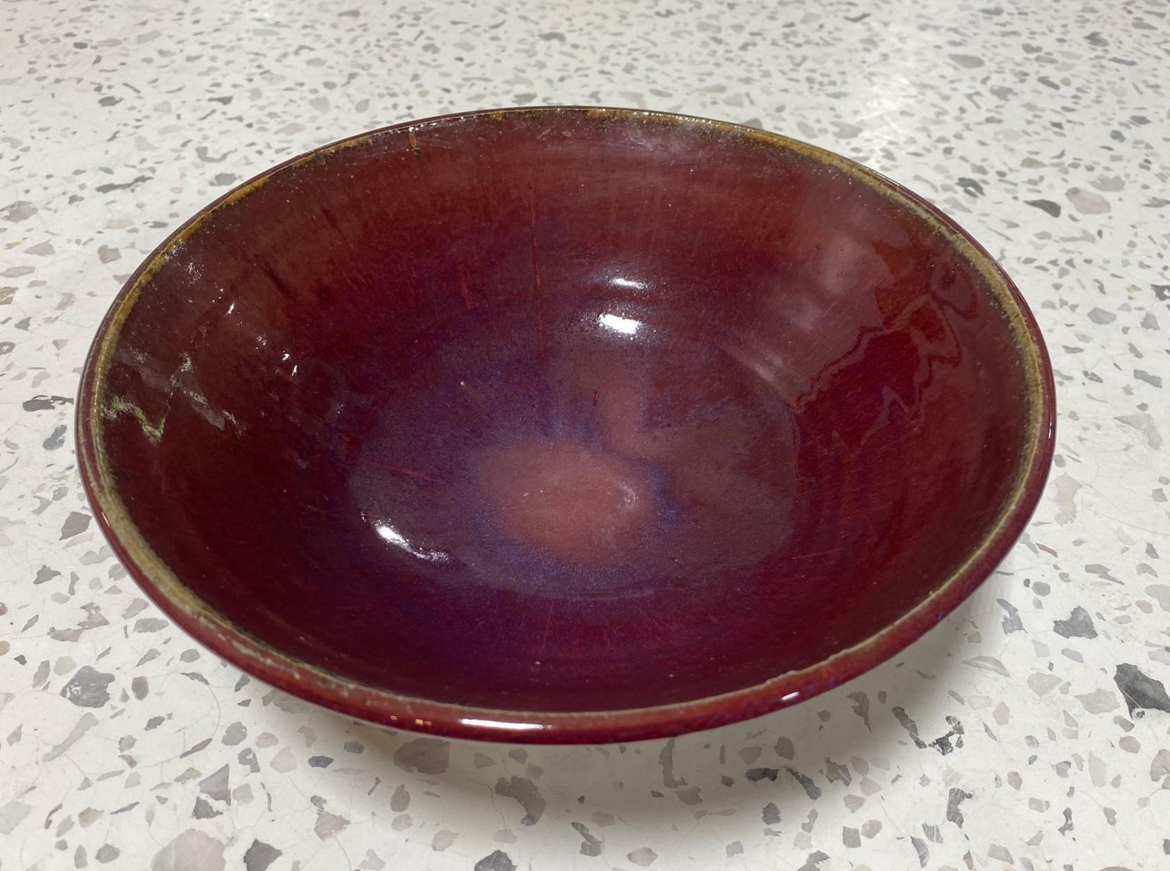 Un grand bol absolument magnifique et merveilleusement émaillé du célèbre maître de la poterie américano-japonaise Toshiko Takaezu. Le bol présente une glaçure luminescente assez rare, d'un rouge sang de bœuf foncé, avec des éclaboussures de