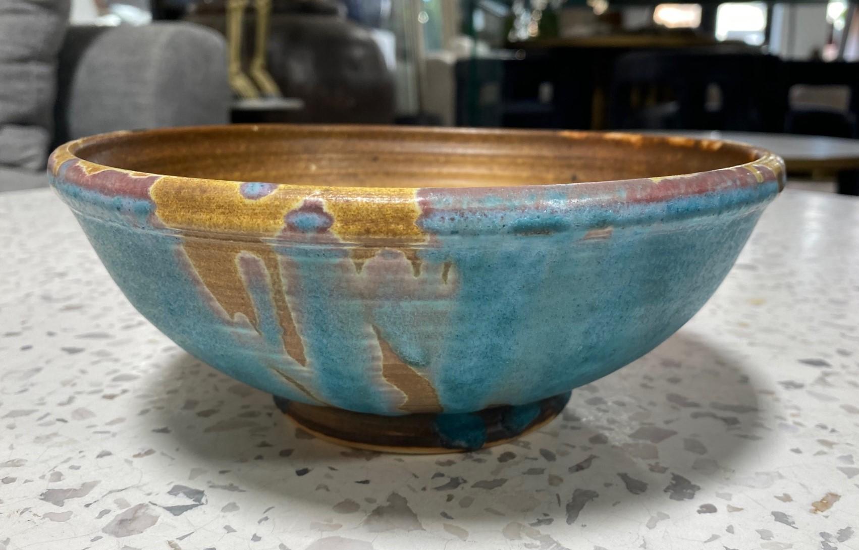 A beautiful and quite engaging relatively large sumptuously glazed bowl by famed Japanese Hawaiian American pottery master Toshiko Takaezu. The high-fired porcelain bowl features a vast array of shifting, vibrant, and colorful glazes (with earth