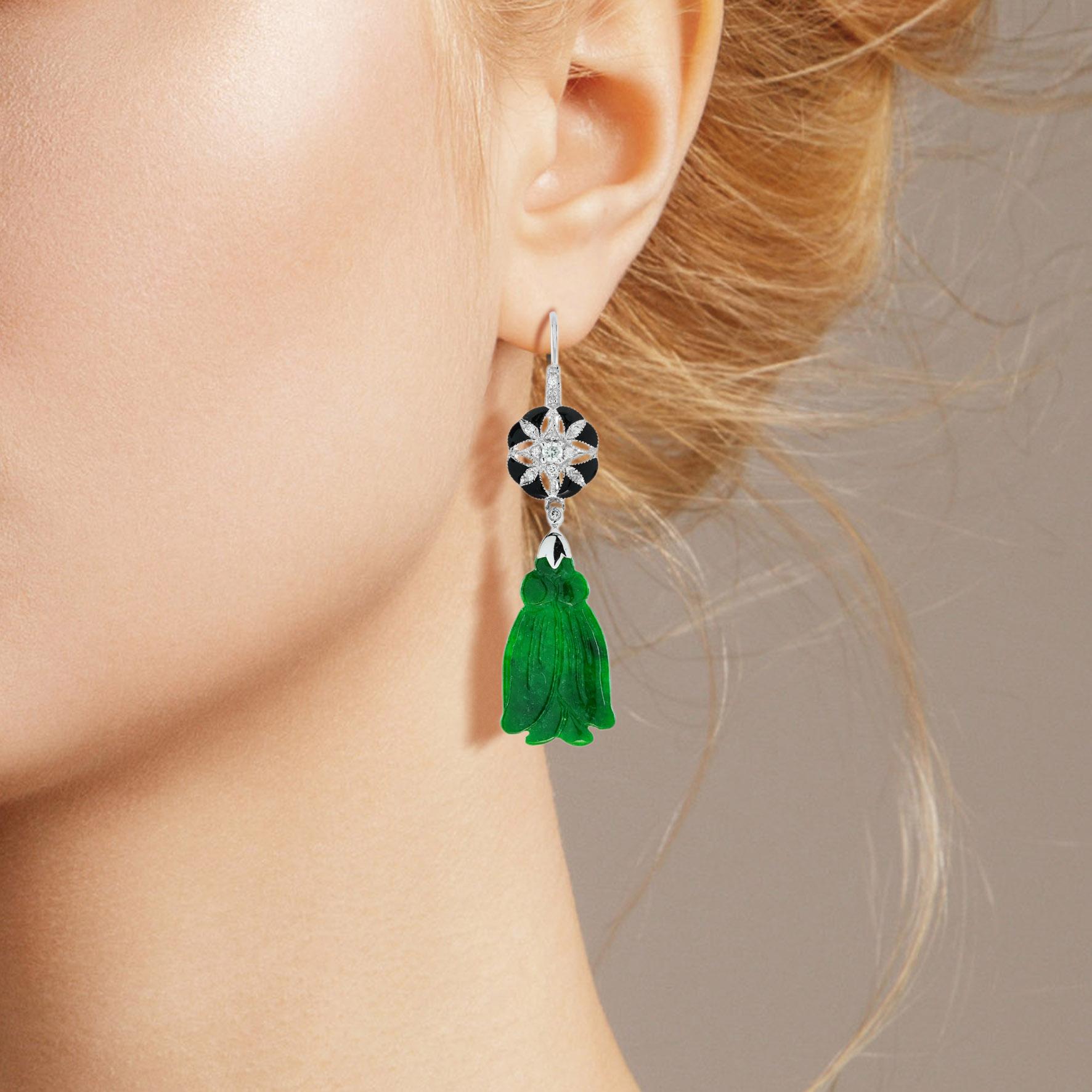 The natural jade in these lovely earrings has some very special shape. Both pieces have a strong green color and well tassel carvings. The jade is suspended in a 9k white gold setting with diamond and enamel floral on the top. The earrings transfer
