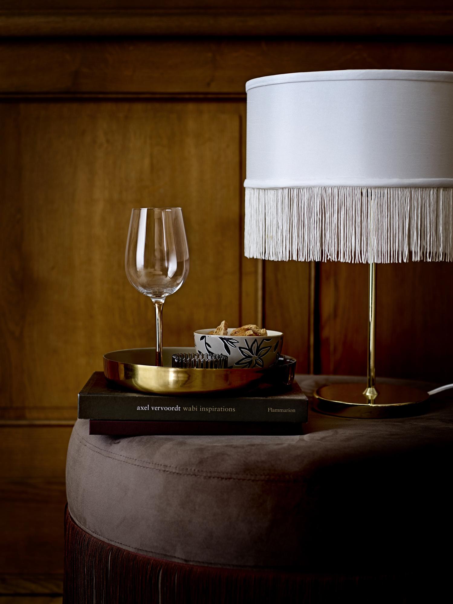 Upholstered velour tasseled ottoman seating pouf in chocolate brown.