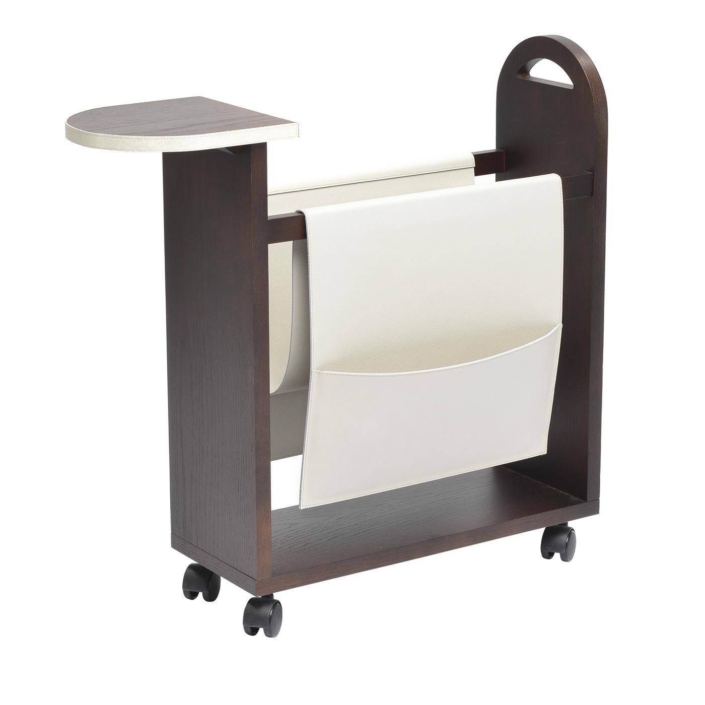 This elegant and extremely versatile piece is a magazine rack made in durmast wood with two large side pockets, one small back pocket and one front shelf in leather that can be either in calfskin with water- and scratch-resistant finish, or in