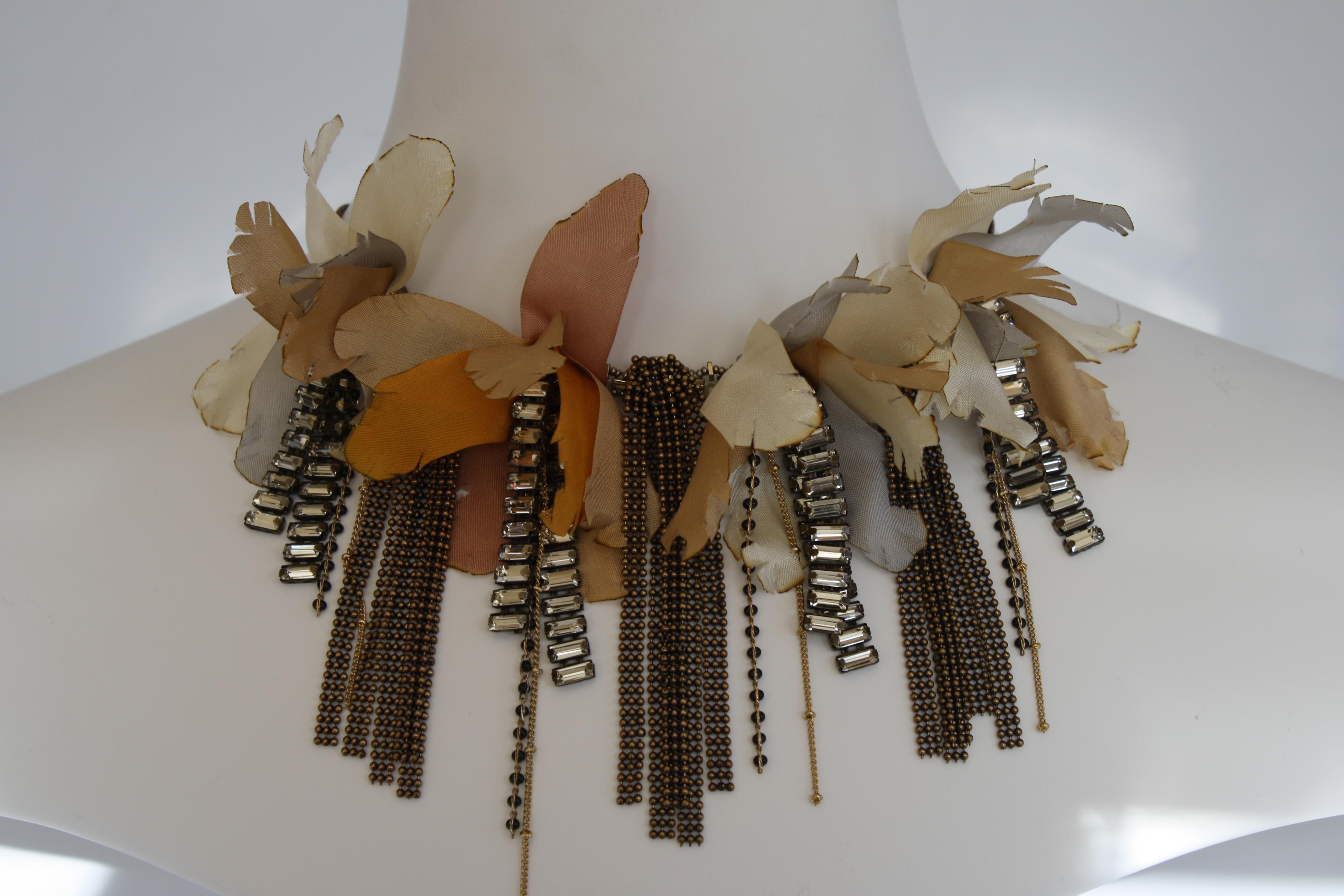 Collier de fleurs en ruban de lurex avec chaîne en laiton et baguettes en verre du designer italien Tataborello. 

19
