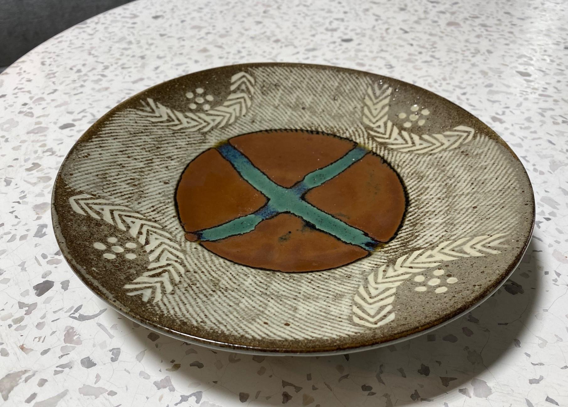 A wonderfully decorated and executed ceramic low bowl/ plate by Japanese National Treasure pottery master Tatsuzo Shimaoka. This work exhibits his signature rope and slip inlay with kaki glaze, wax resist, and green trailed decoration and displays