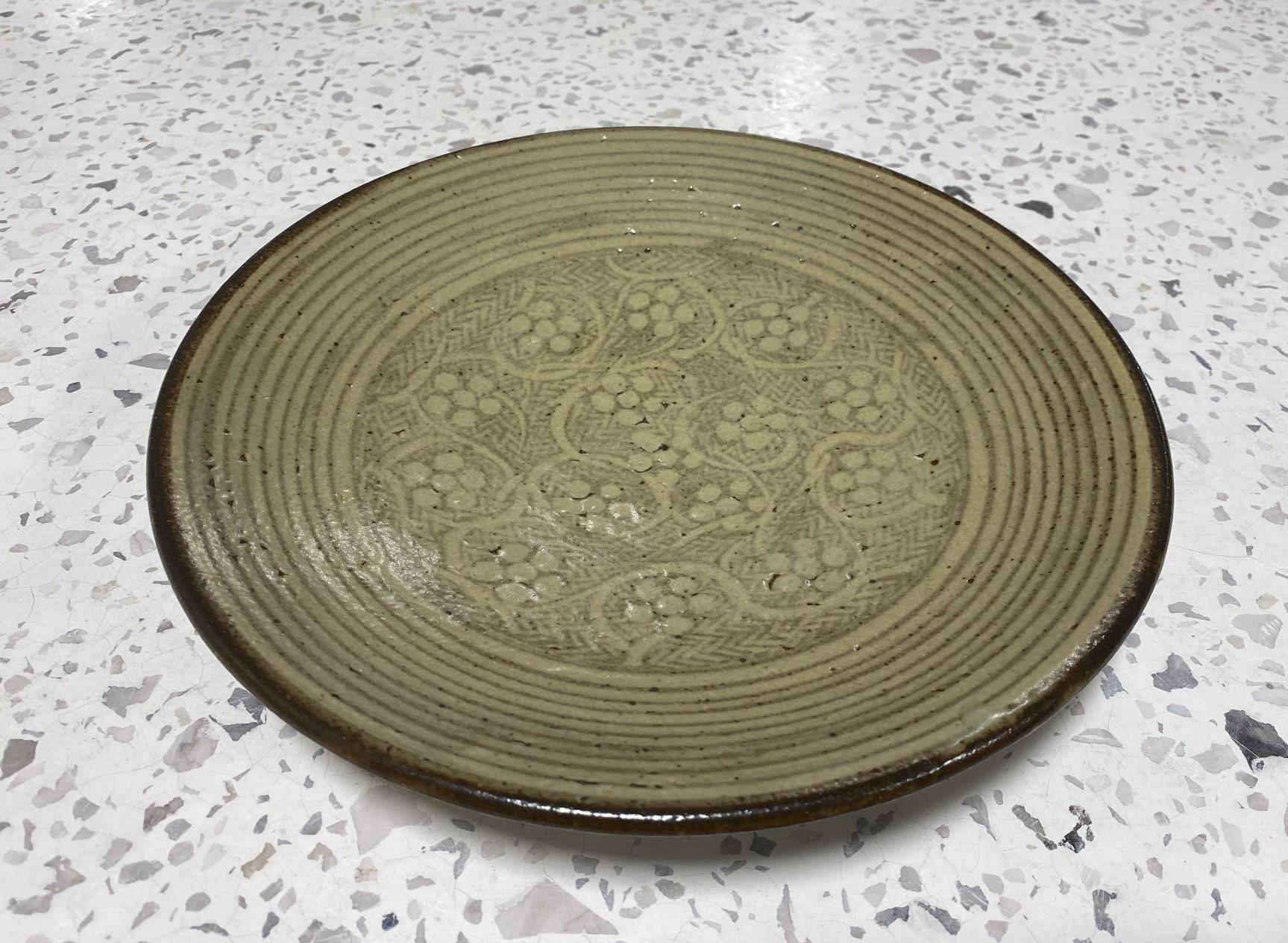 A wonderfully decorated and executed large Mingei pottery plate/charger by Japanese National Treasure Mashiko-yaki ceramic master Tatsuzo Shimaoka. This work exhibits his signature rope and slip inlay (Zogan-Sara inlaid pottery plate) in a circular