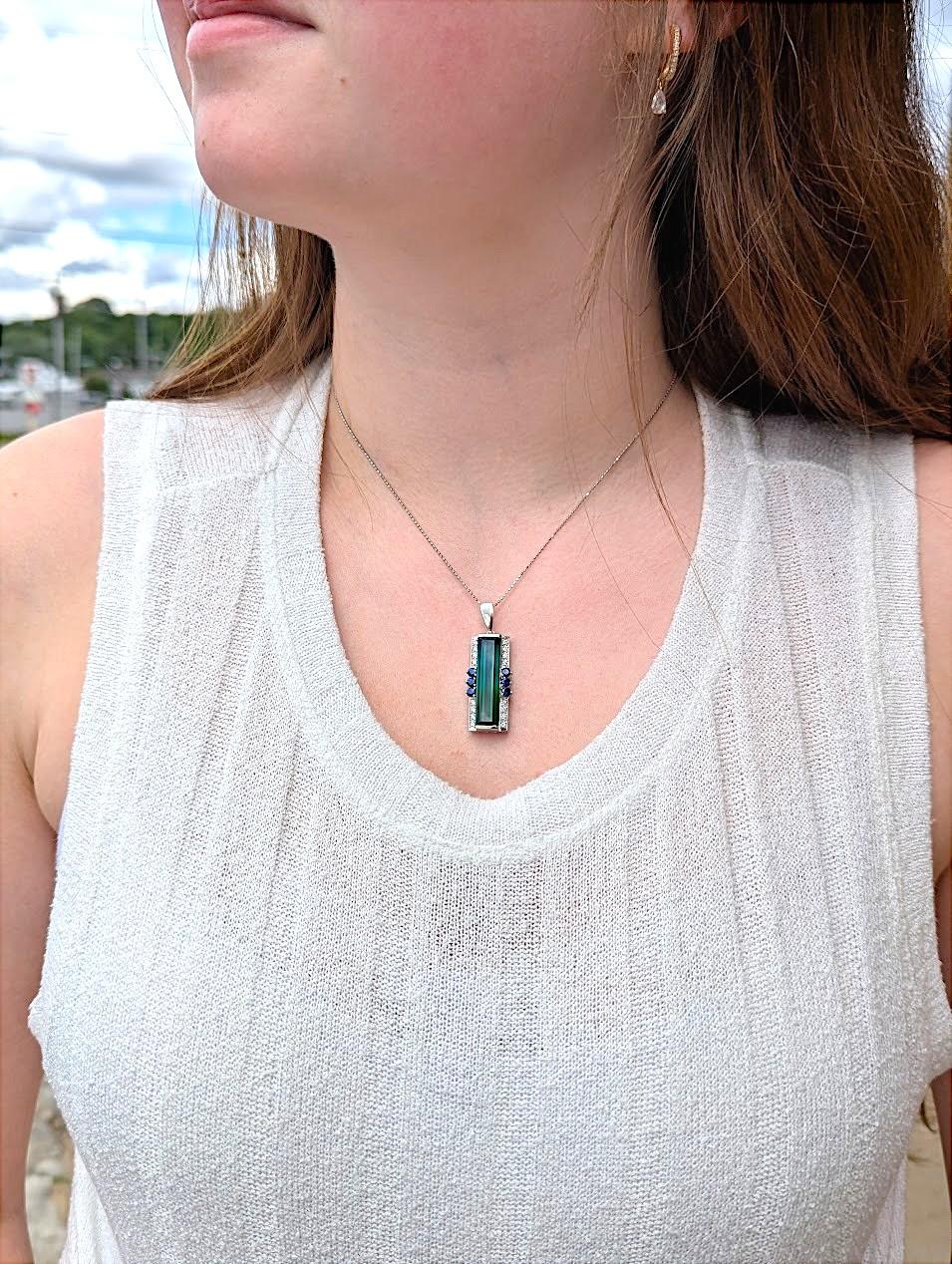 Bold. Rare. Unforgettable. The Tatum Necklace by Mountain Song Jeweler is a radiant masterpiece of color and craftsmanship. At its center gleams an extraordinary 12.24 carat natural tourmaline, displaying vibrant depth and character that commands
