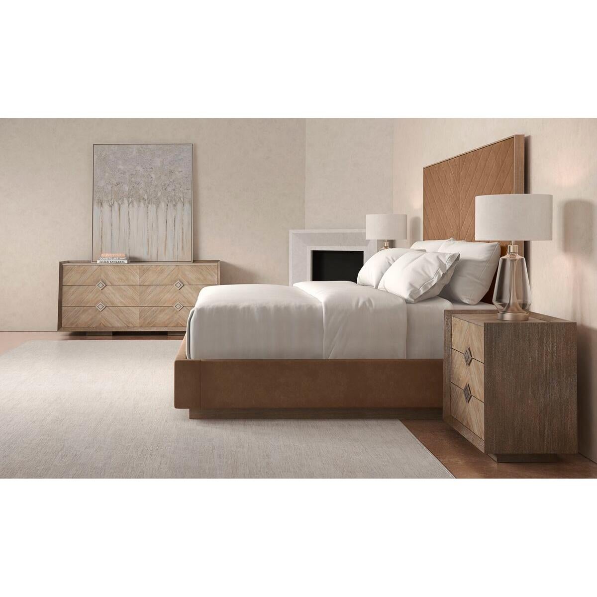 Upholstered king bed with an Ash Driftwood finish frame. It has a tall upholstered headboard with a modern channel tufting design of converging angles that meet in the center to create a mesmerizing chevron. This bed’s fully finished sides appear to