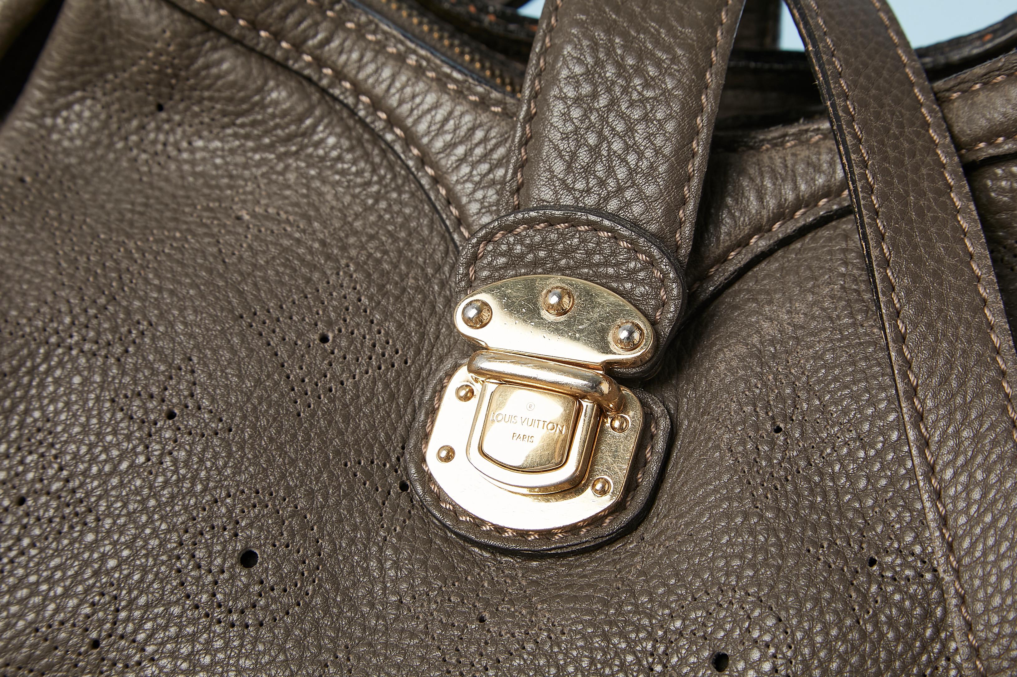 Taupe color monogram perforated crossbody bag with branded studs.Inside strap to attach the keys. Zip  and claps to close it. Lenght of the shoulder strap= 95 cm
Suede lining.