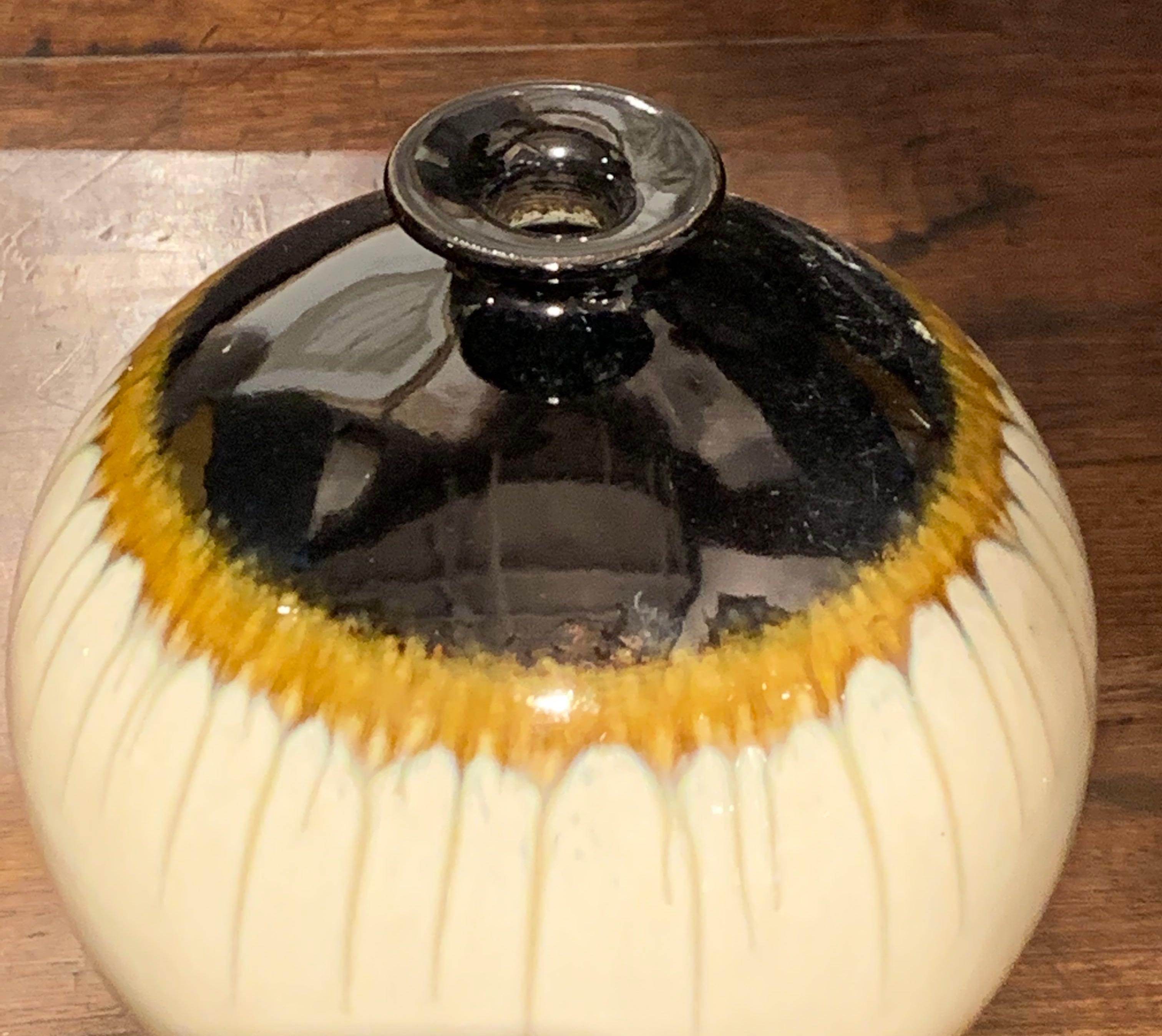 Contemporary Chinese ceramic vase with decorative drip glaze.
The shape is round with a narrow top. Shades of taupe, cream and dark brown/black.
Uneven horizontal line in the middle of the vase.


 