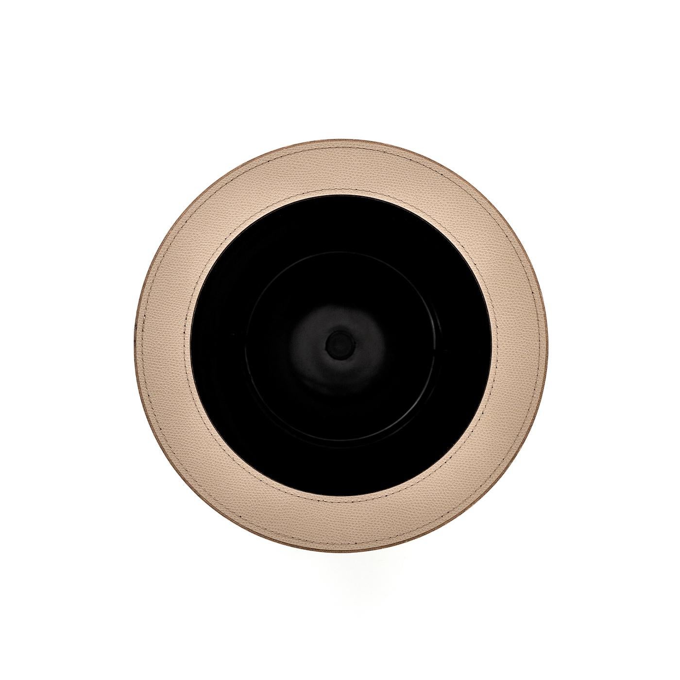 Questo cestino per la carta, elegante e innovativo, è interamente rivestito in pelle incollata Malaga, in un versatile color tortora. Realizzato in plastica nera per un uso facile e pratico, è dotato di un coperchio aperto e rimovibile che gli