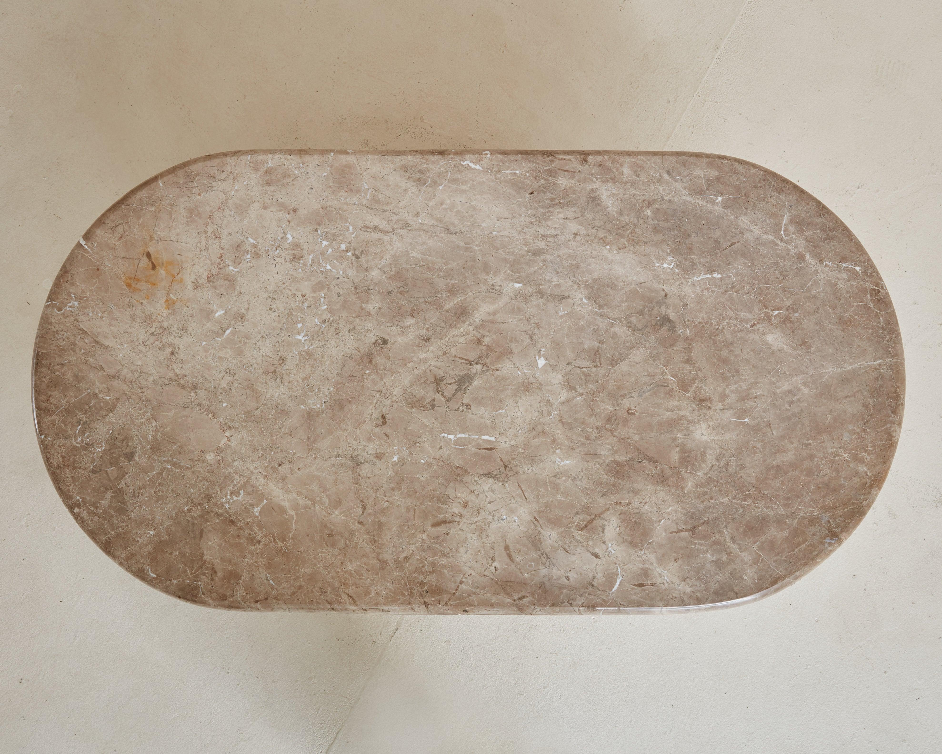 Table basse postmoderne des années 1980 dans le style de Roche Bobois. Cette pièce étonnante est fabriquée en marbre taupe avec des variations de gris doux et de blanc cassé dans le veinage. Le plateau de table en forme de pilier a un bord en